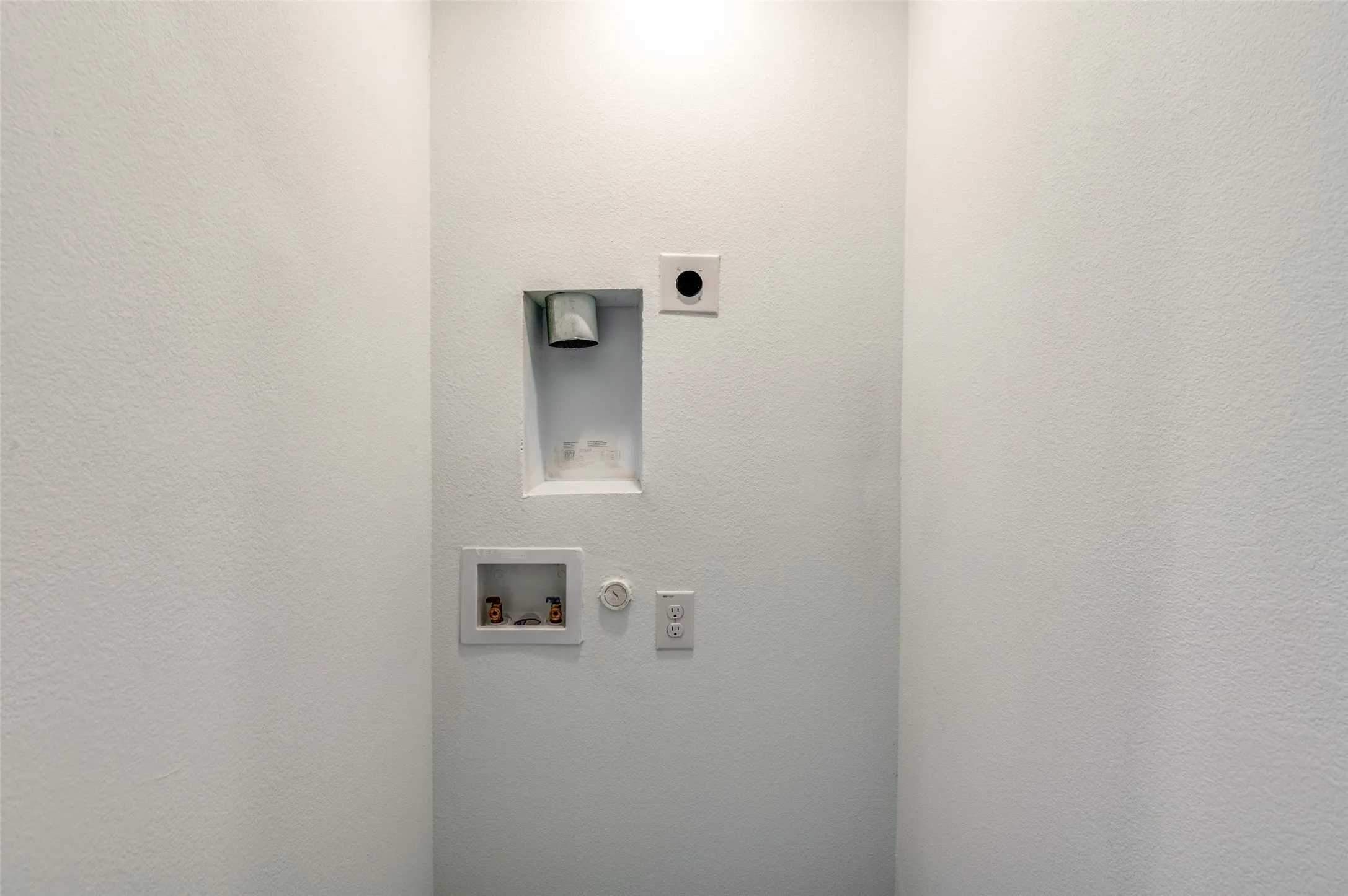 Clothes washing area with gas dryer hookup, washer hookup, and hookup for an electric dryer