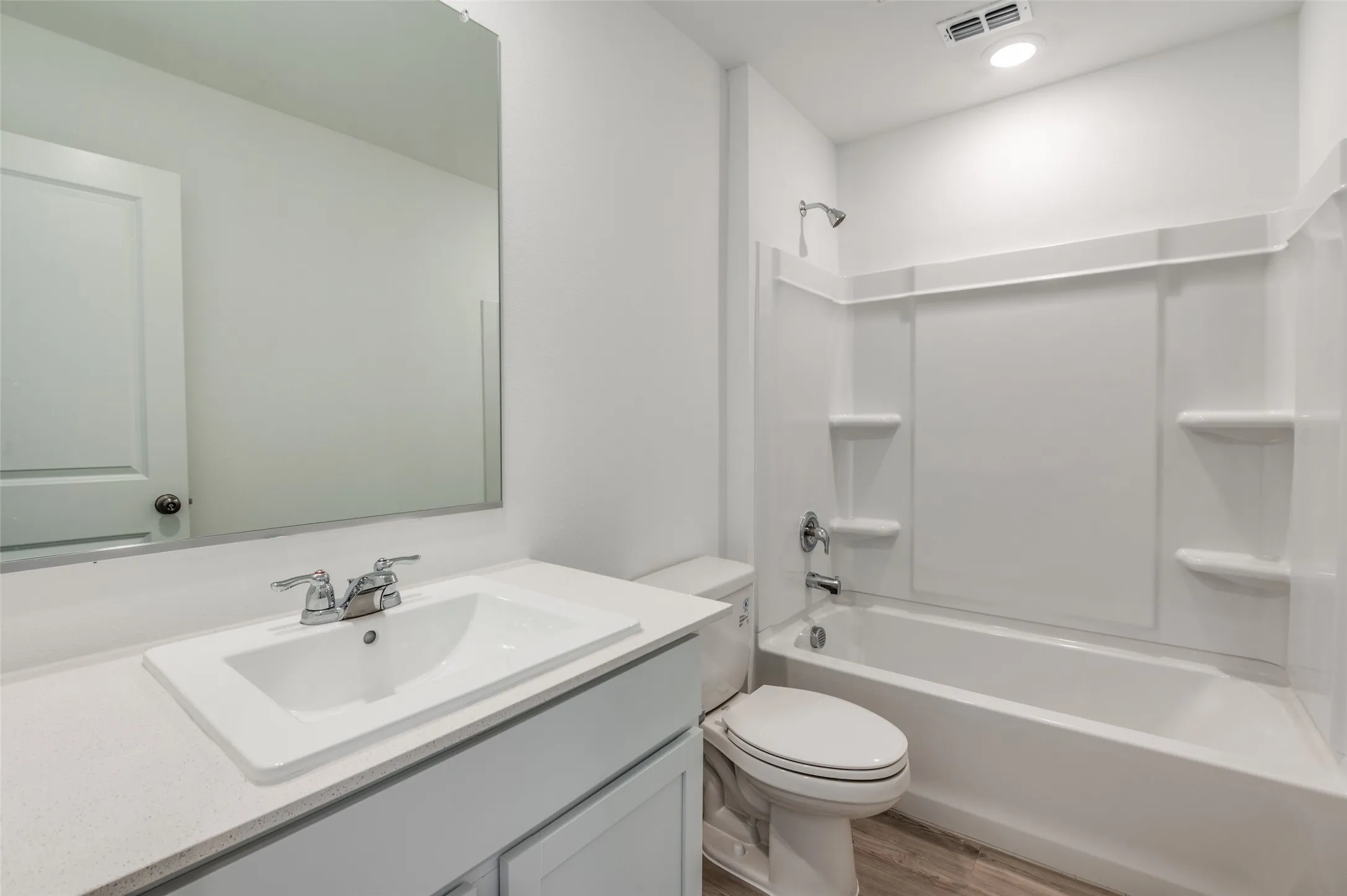 Full bathroom featuring wood-type flooring, tub / shower combination, vanity, and toilet