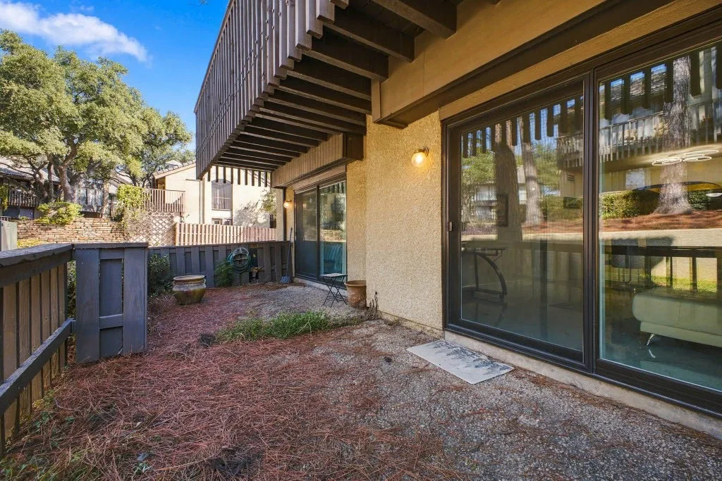 Private outdoor patio featuring a privacy fence and stucco exterior