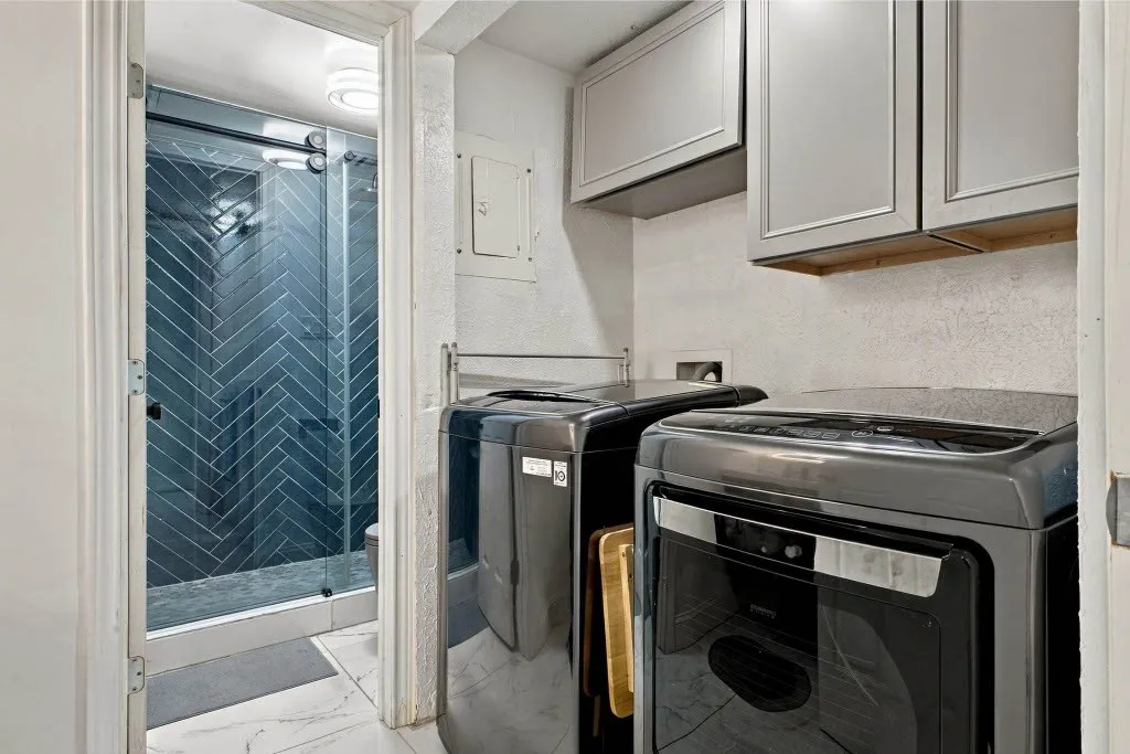 Walk-in shower with herringbone tile, glass sliding door, and overhead lighting