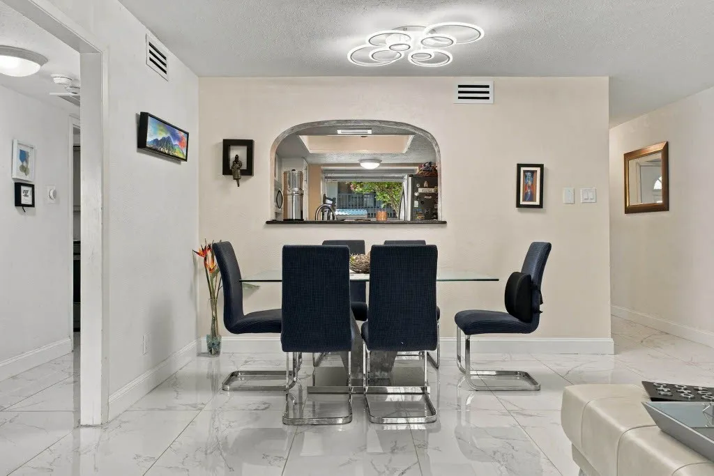 Arched pass-through window, modern ceiling fixture, white tile flooring, recessed lighting, and light-toned walls