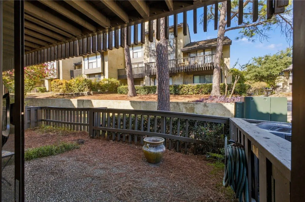 Covered patio with slatted wood ceiling and wood railing