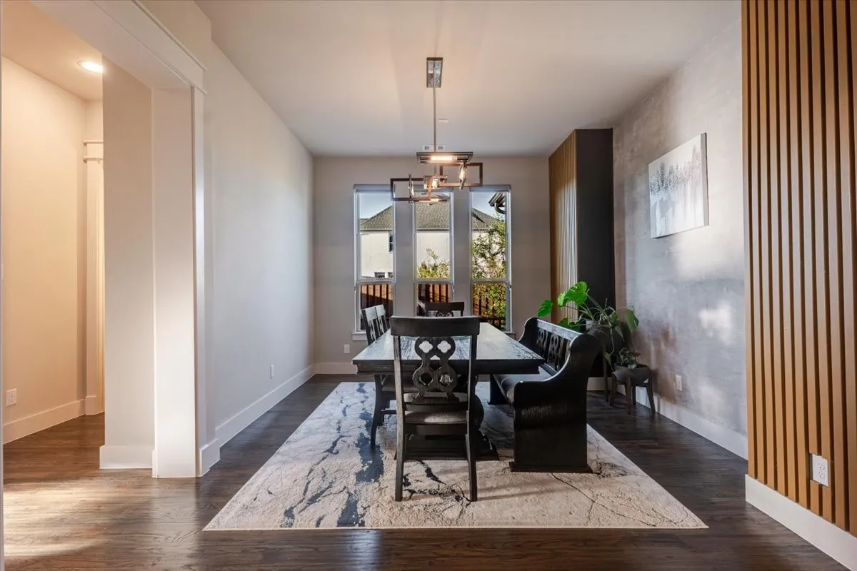 Dining area featuring dark wood-finish flooring, recessed lighting, and a contemporary chandelier