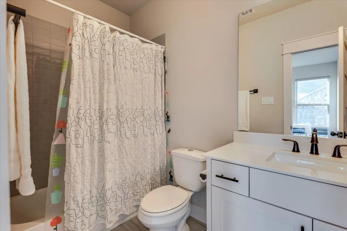 White vanity with dark hardware, undermount sink, and white countertop
