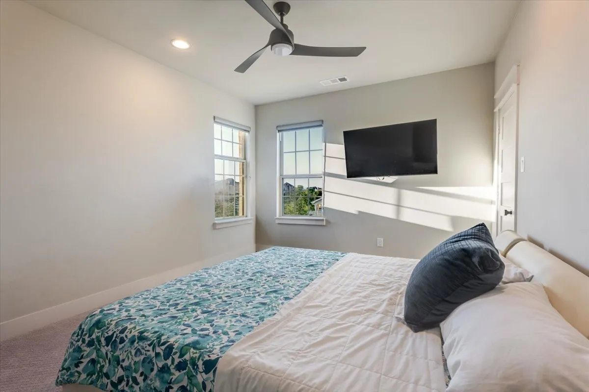 Recessed lighting, ceiling fan, twin paned windows, wall-mounted television, and neutral wall tones