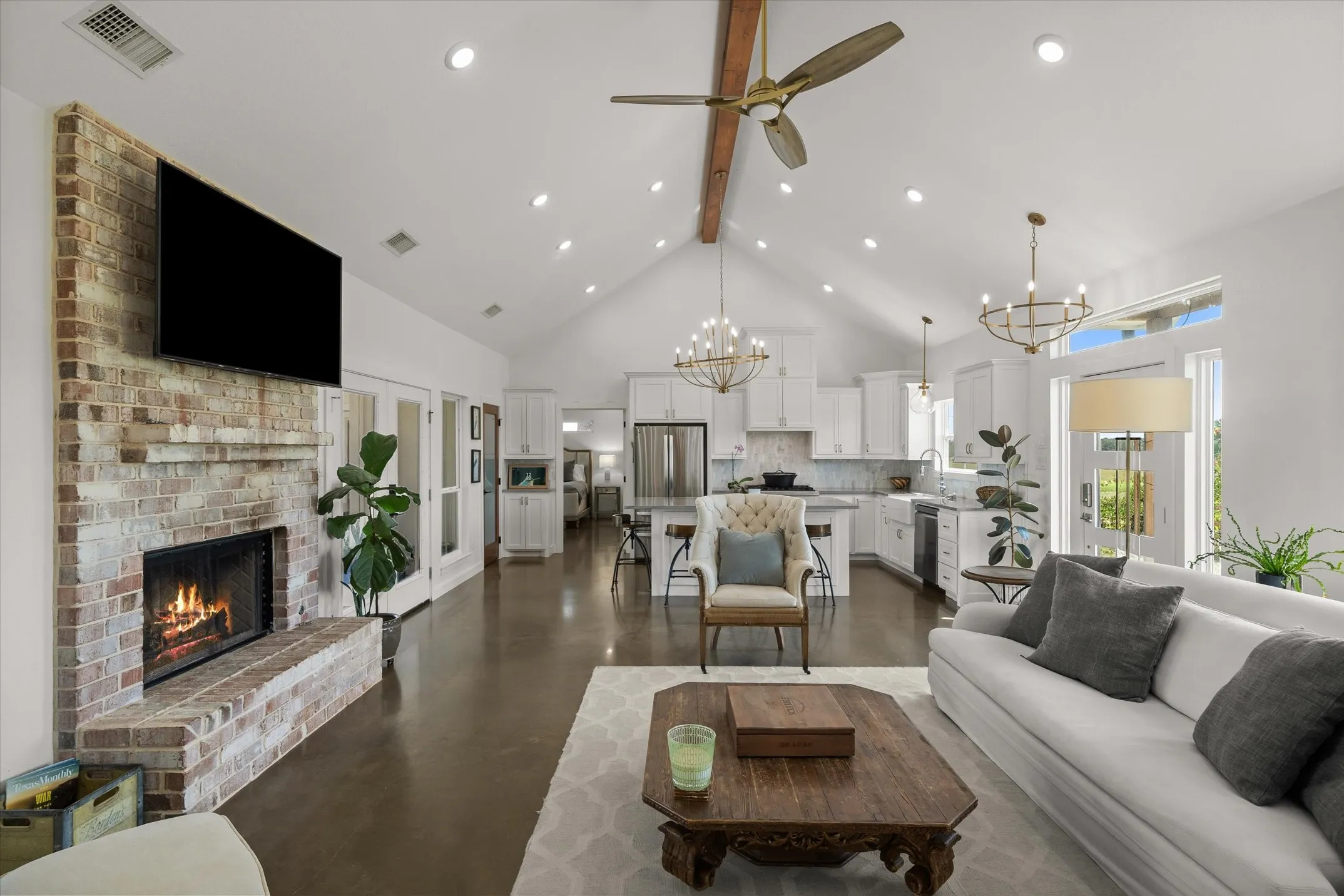 Vaulted ceiling with exposed wood beam, recessed lighting, and a ceiling fan