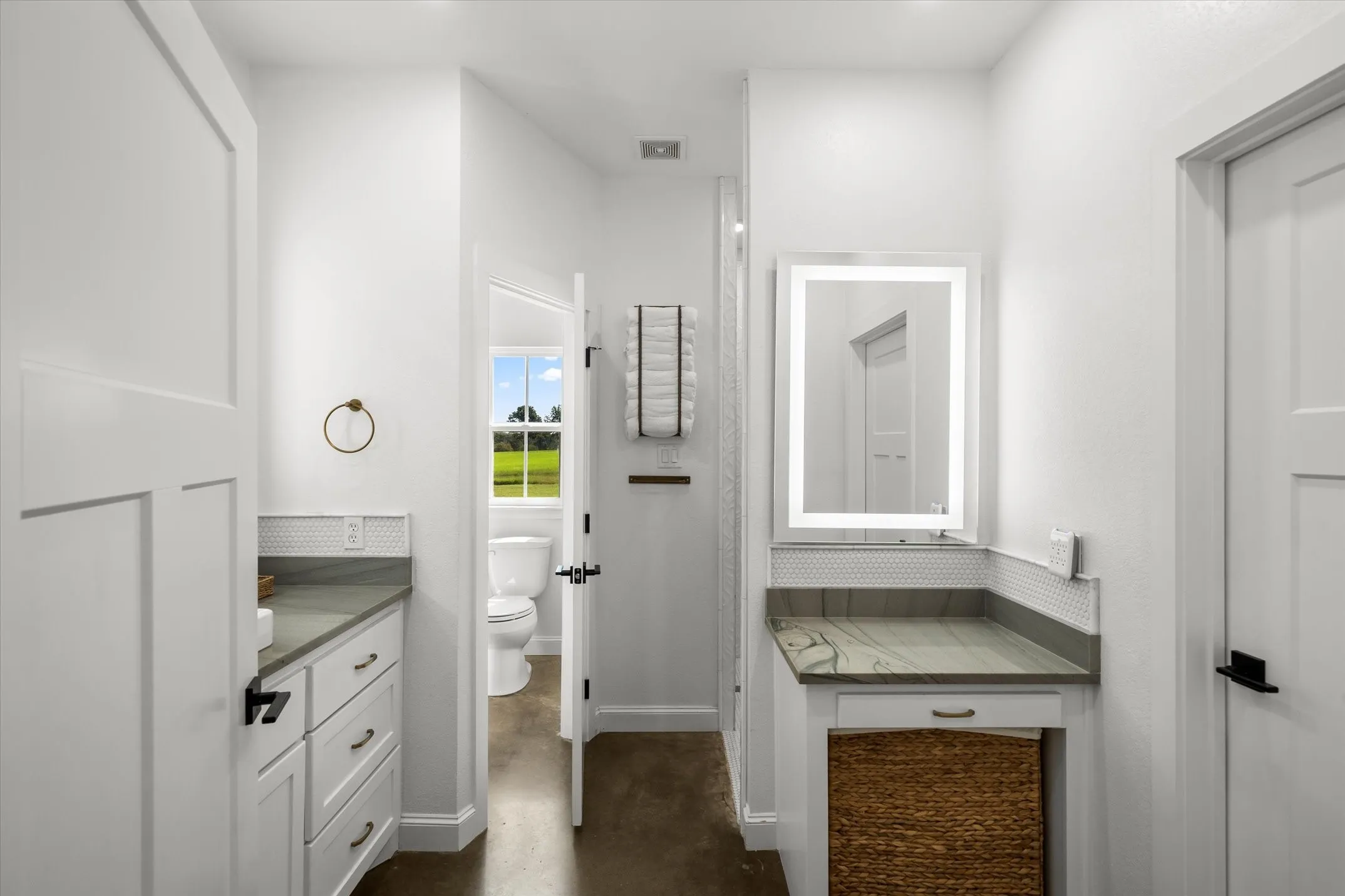 White shaker-style cabinetry with dark hardware, stone countertops, and white hexagon tile backsplash