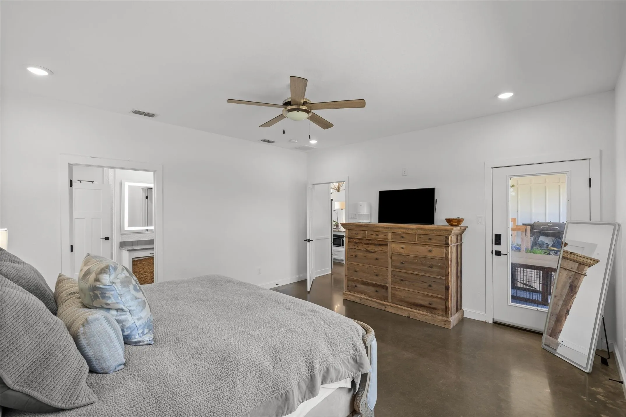 Recessed ceiling lighting, ceiling fan with integrated light, concrete-finish flooring, white paneled doors, and a glass-paneled exterior door