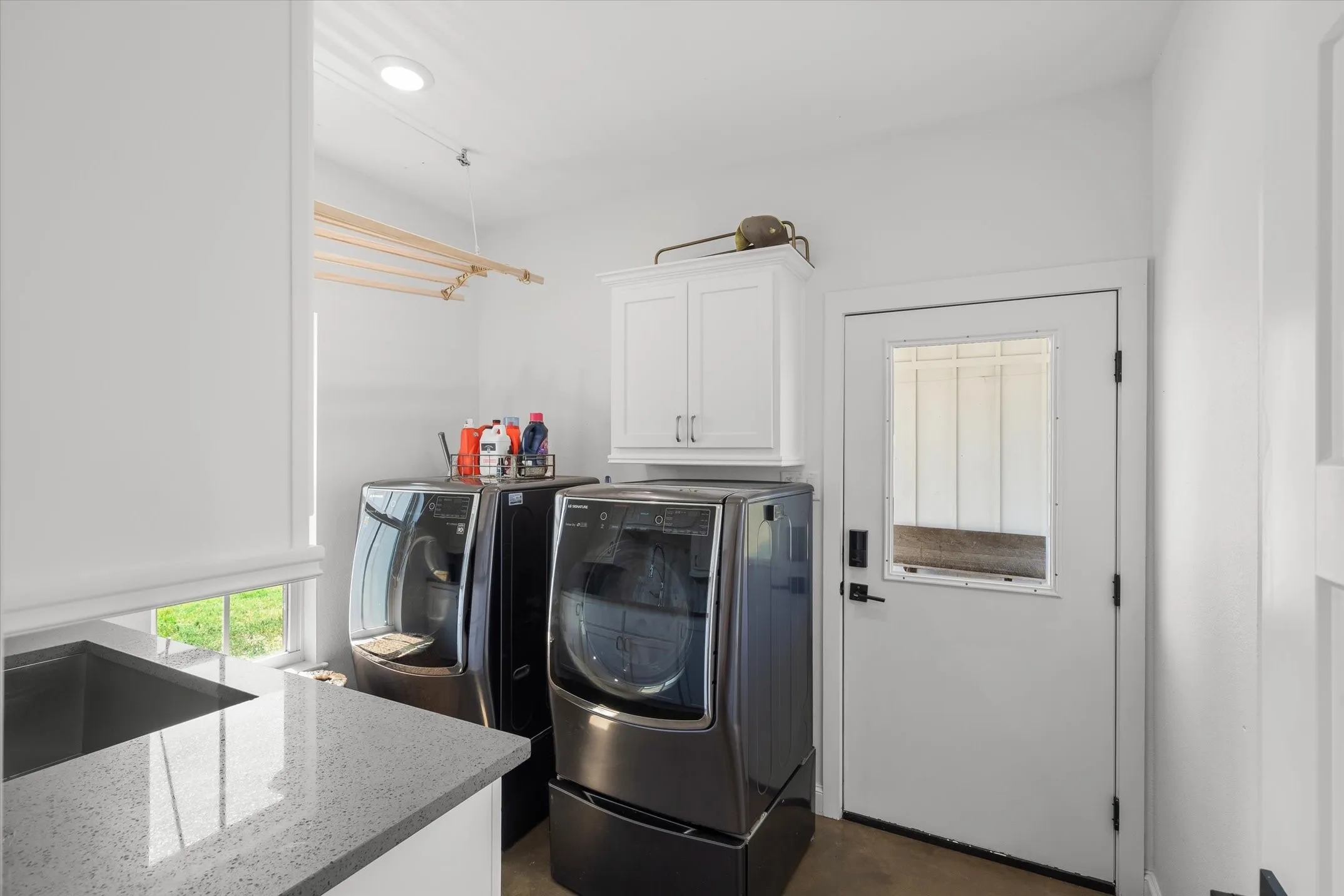 White shaker-style cabinetry, a built-in sink, and a light-toned countertop
