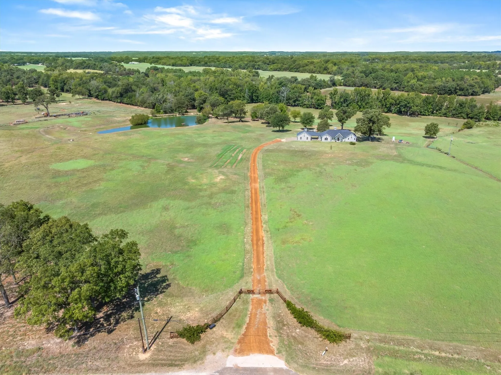 Expansive property featuring a private drive, gated entrance, natural pond, and a large residential structure