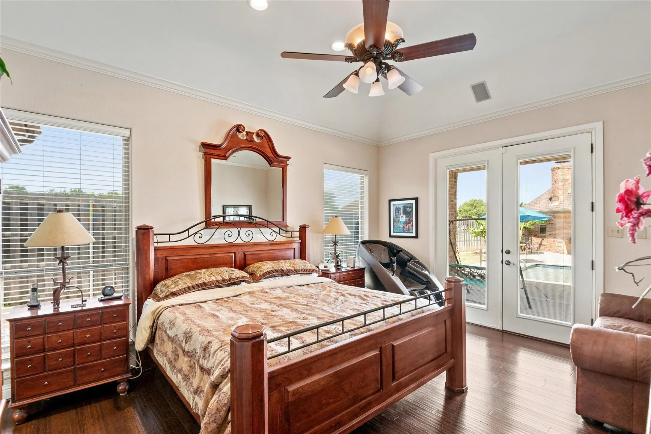 Vaulted ceiling with a ceiling fan, recessed lighting, wood-finish flooring, and double French doors opening to the exterior