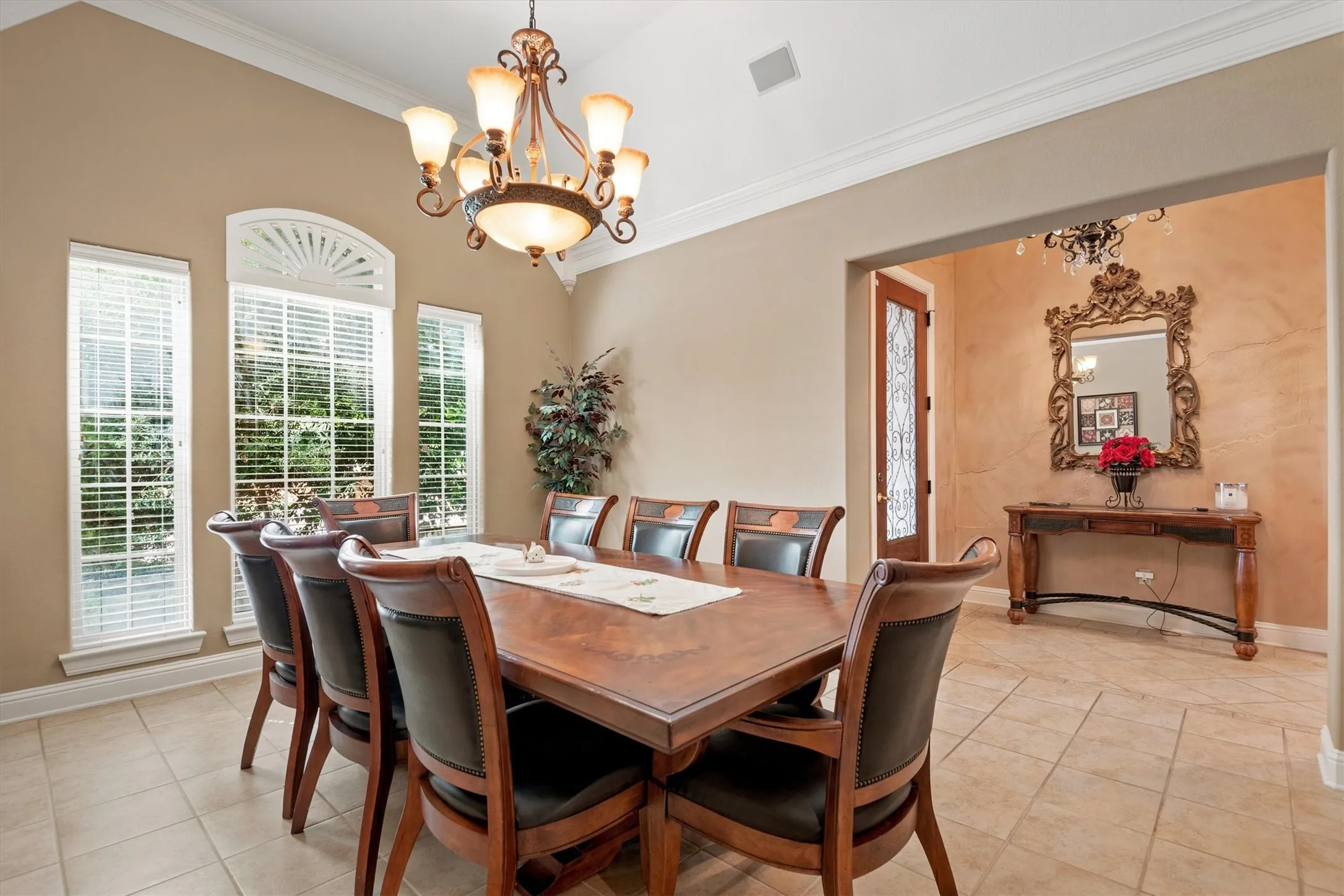 Formal dining area with vaulted ceiling, transom window, tile flooring, and decorative chandelier