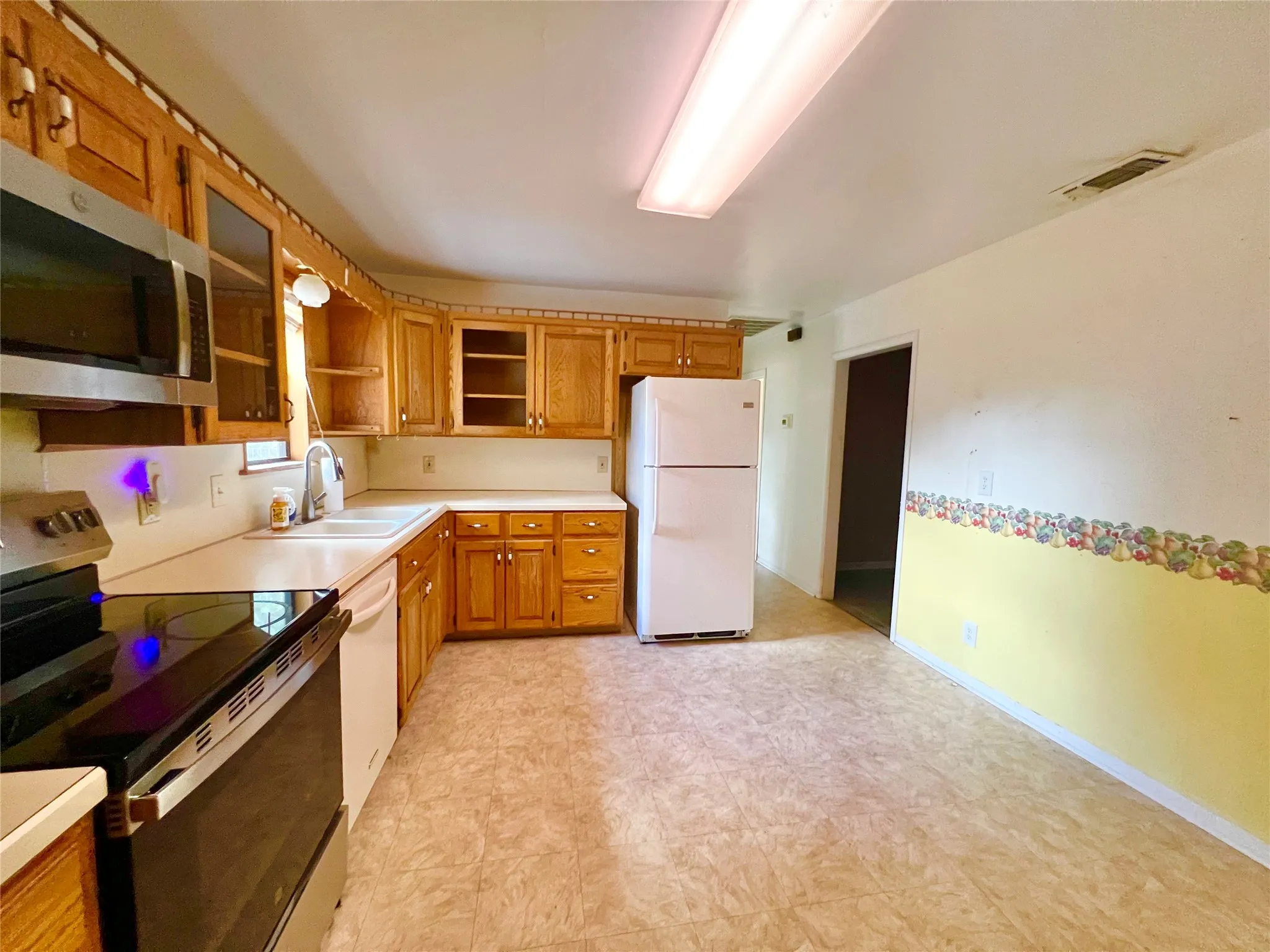 Updated stove, microwave, and kitchen faucet.
