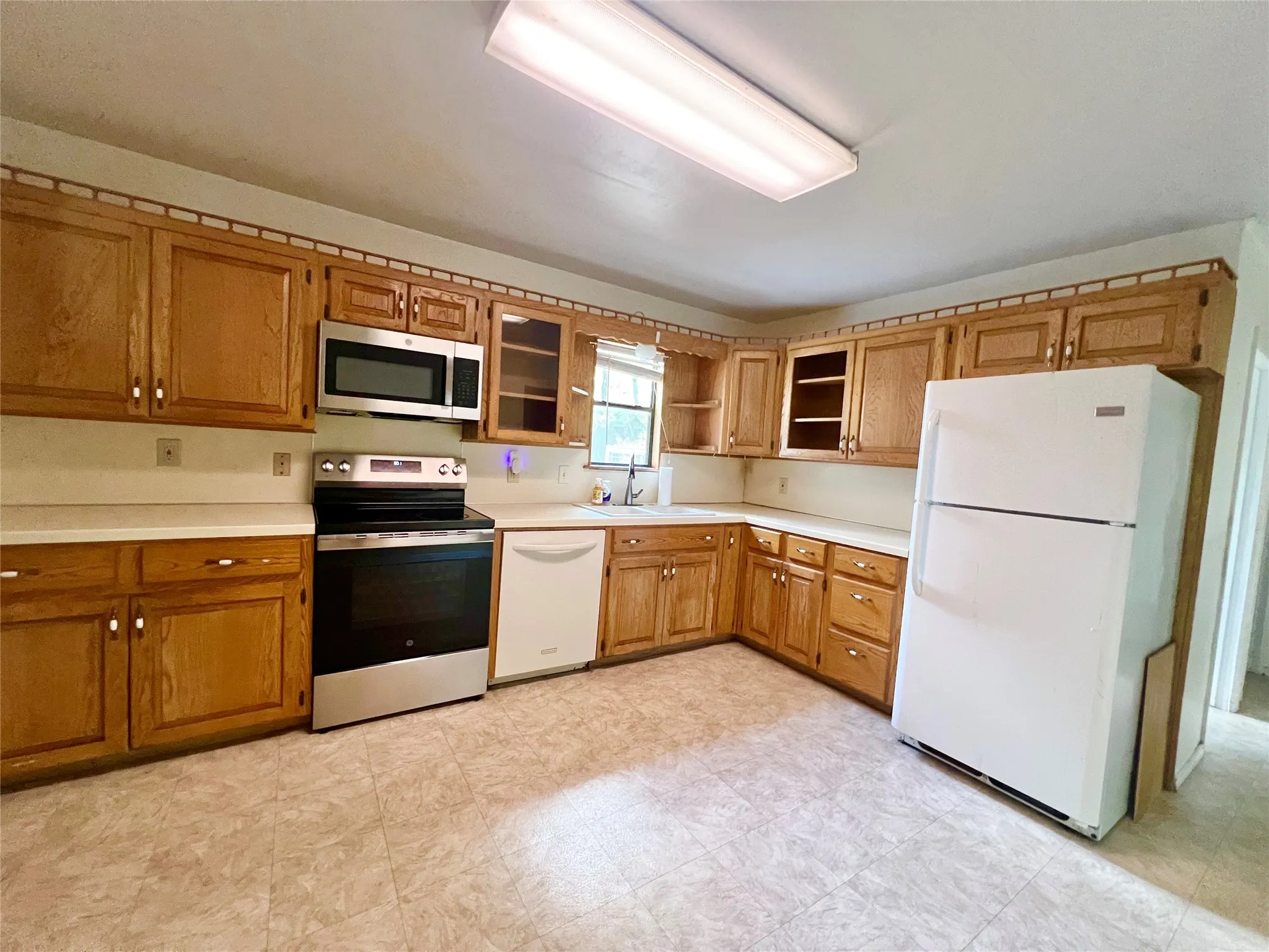 Updated stove, microwave, and kitchen faucet.