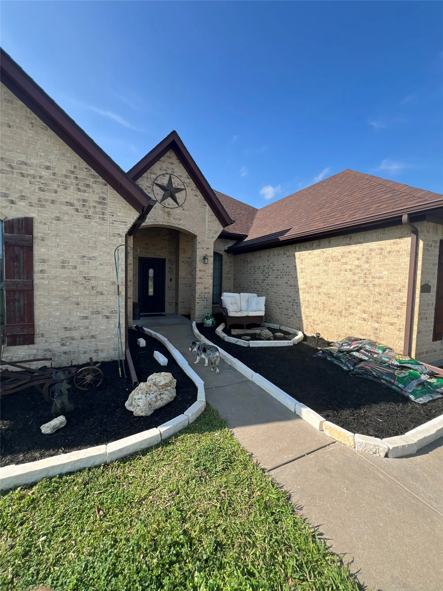 Brick exterior with dark brown roof shingles and matching gutters