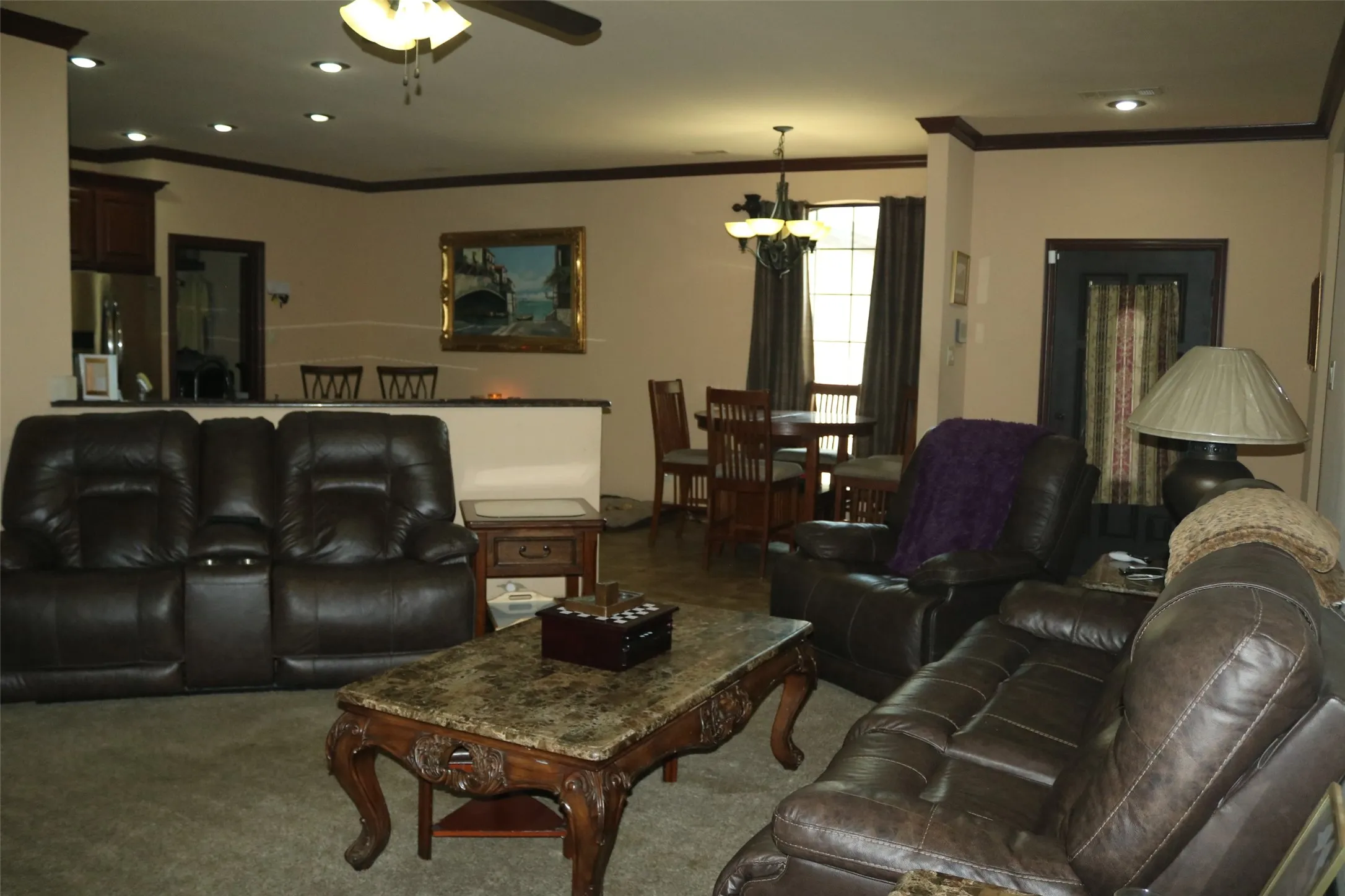 Recessed ceiling lighting, crown molding, ceiling fan, breakfast bar with countertop, and wood-finish flooring