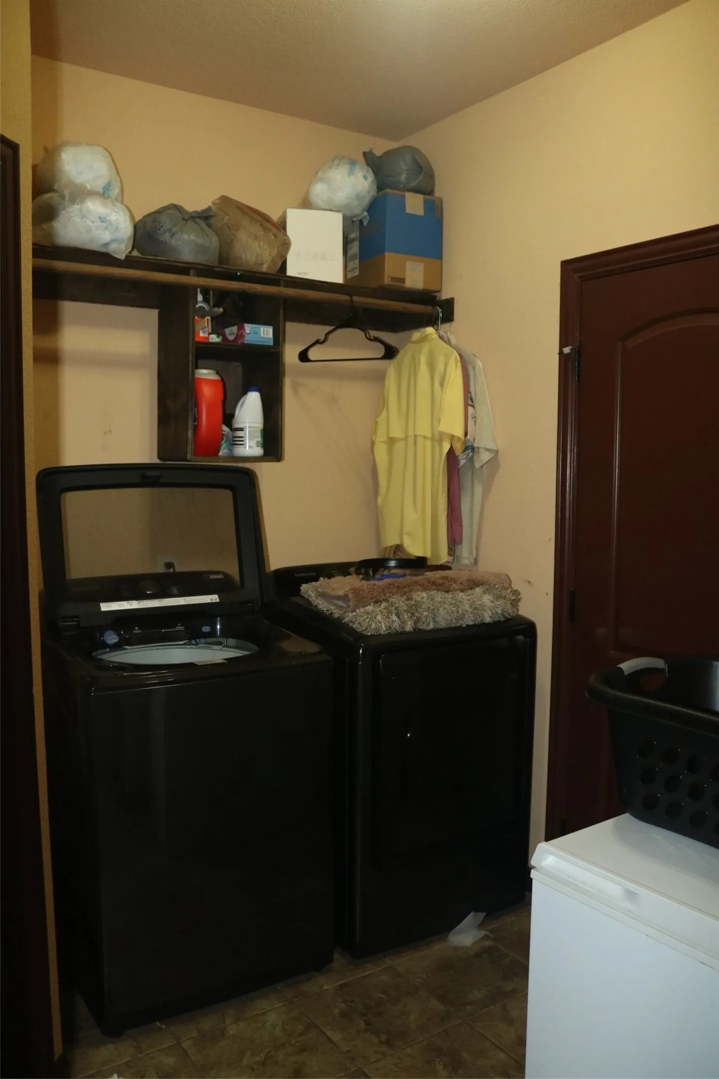 Tile flooring, built-in shelving, and a dark wood-finish door