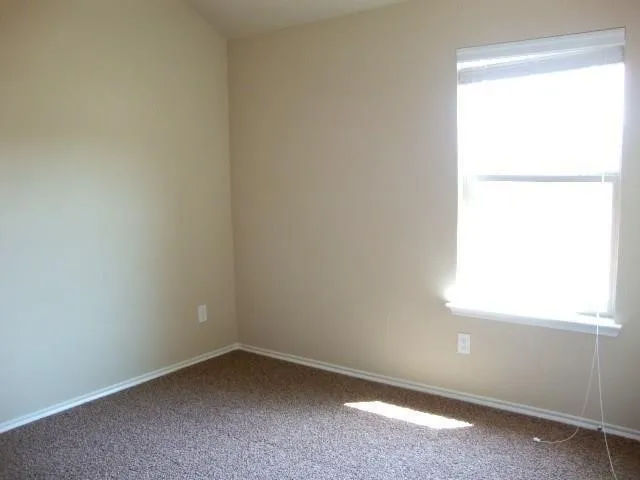 Neutral-toned walls complement the textured carpet flooring