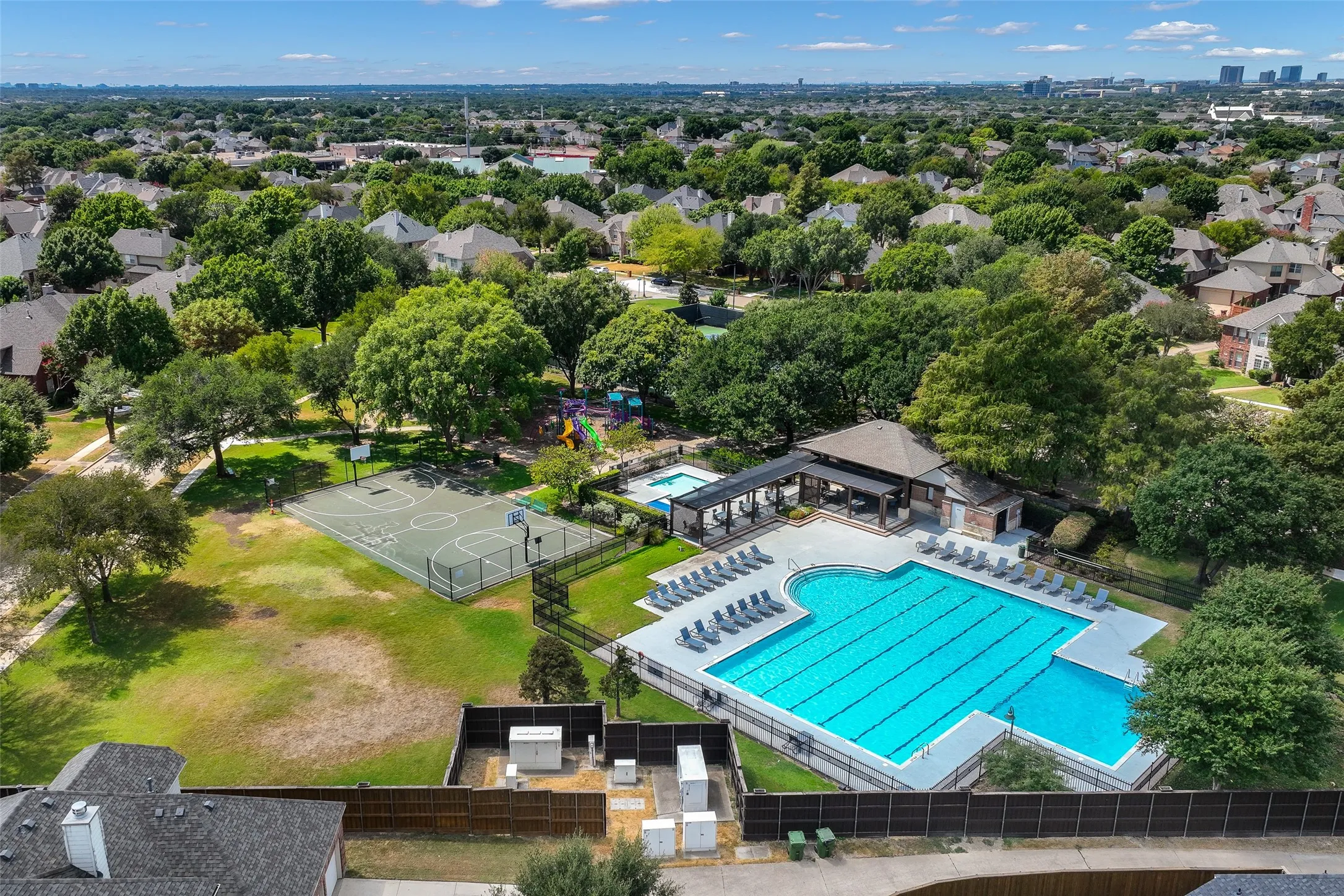 Community pool area with basketball and tennis courts