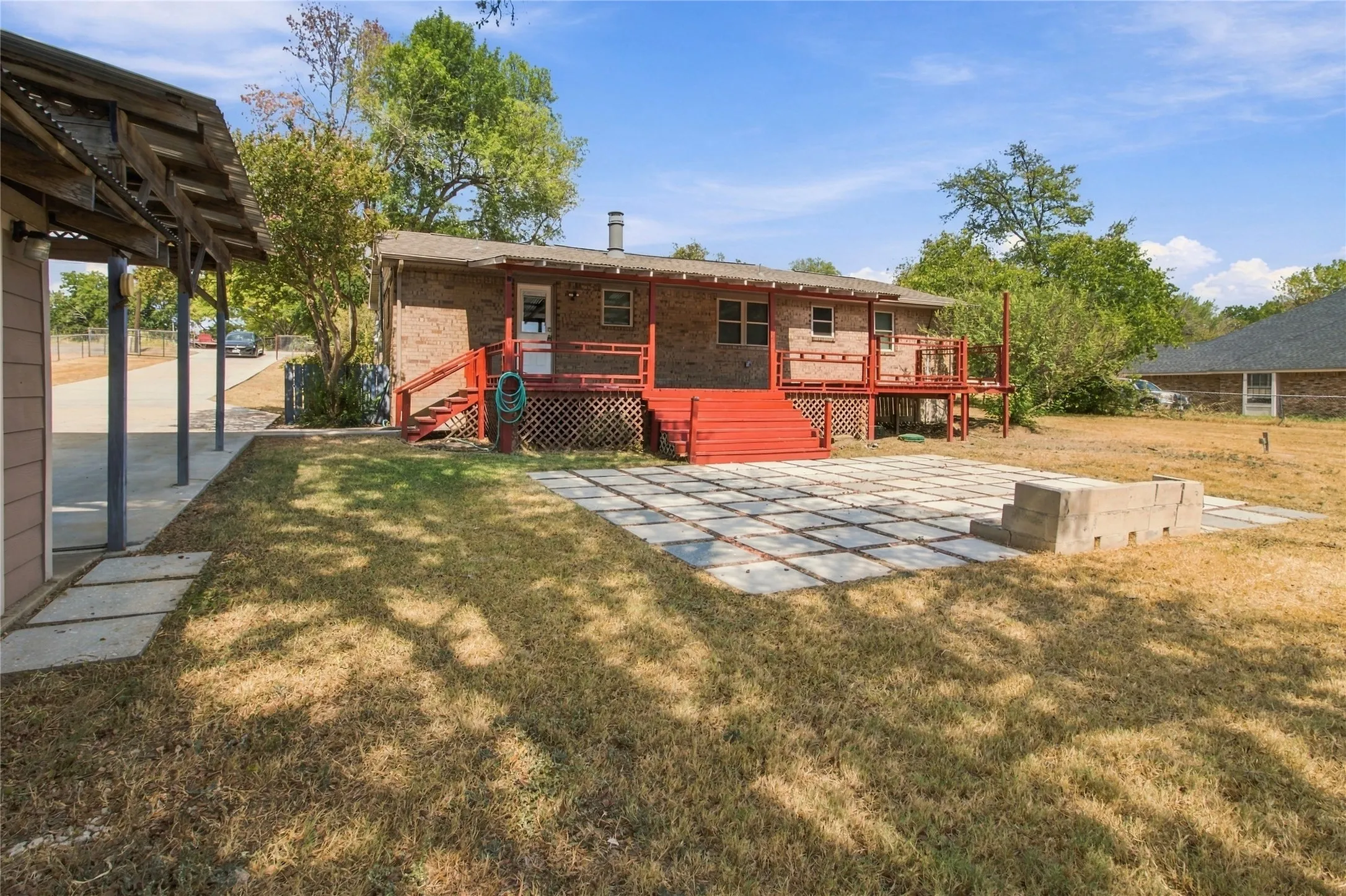 Brick exterior with a red-painted elevated deck and steps