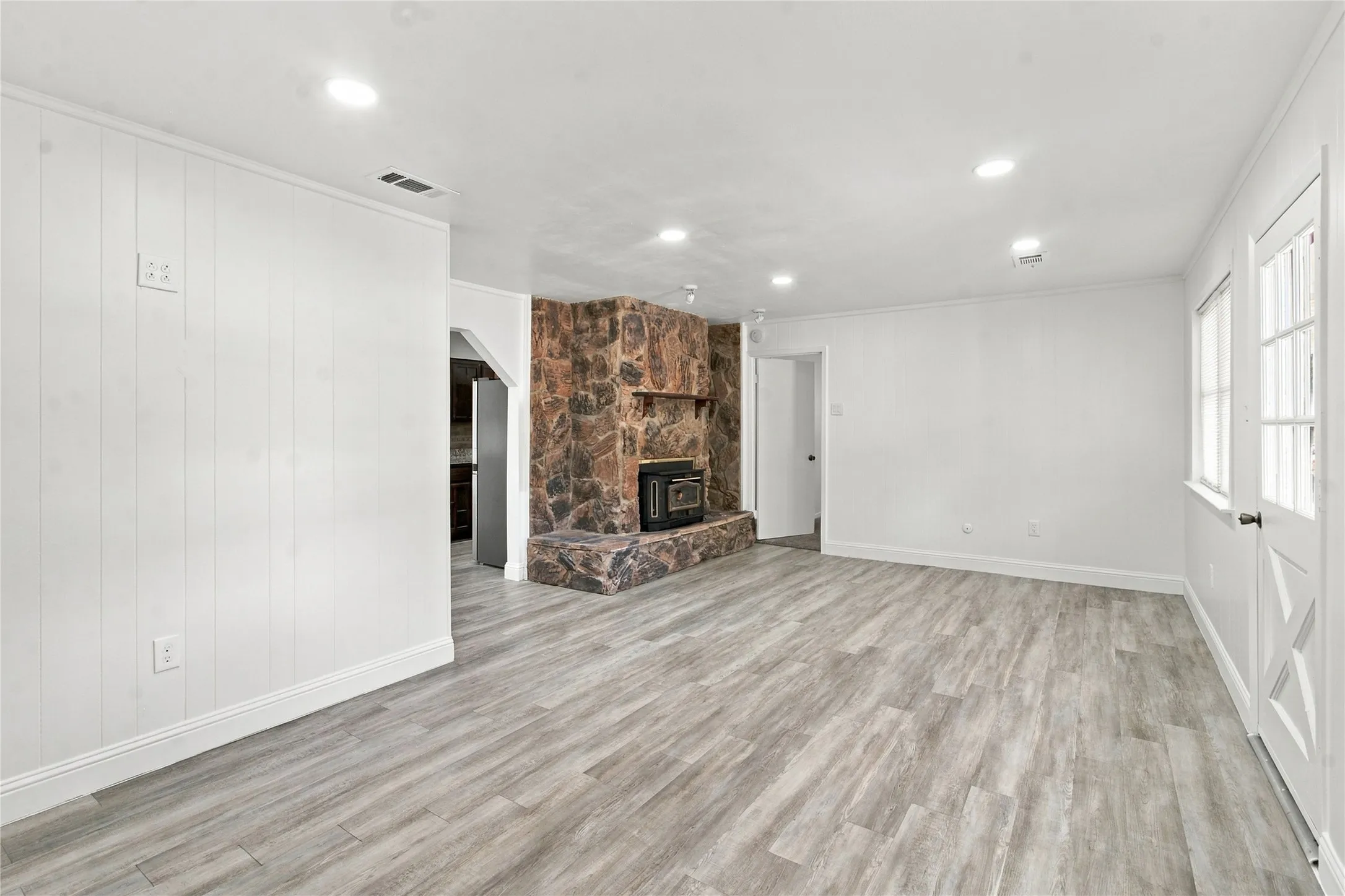 Wood-finish flooring throughout, recessed lighting, and white paneled walls