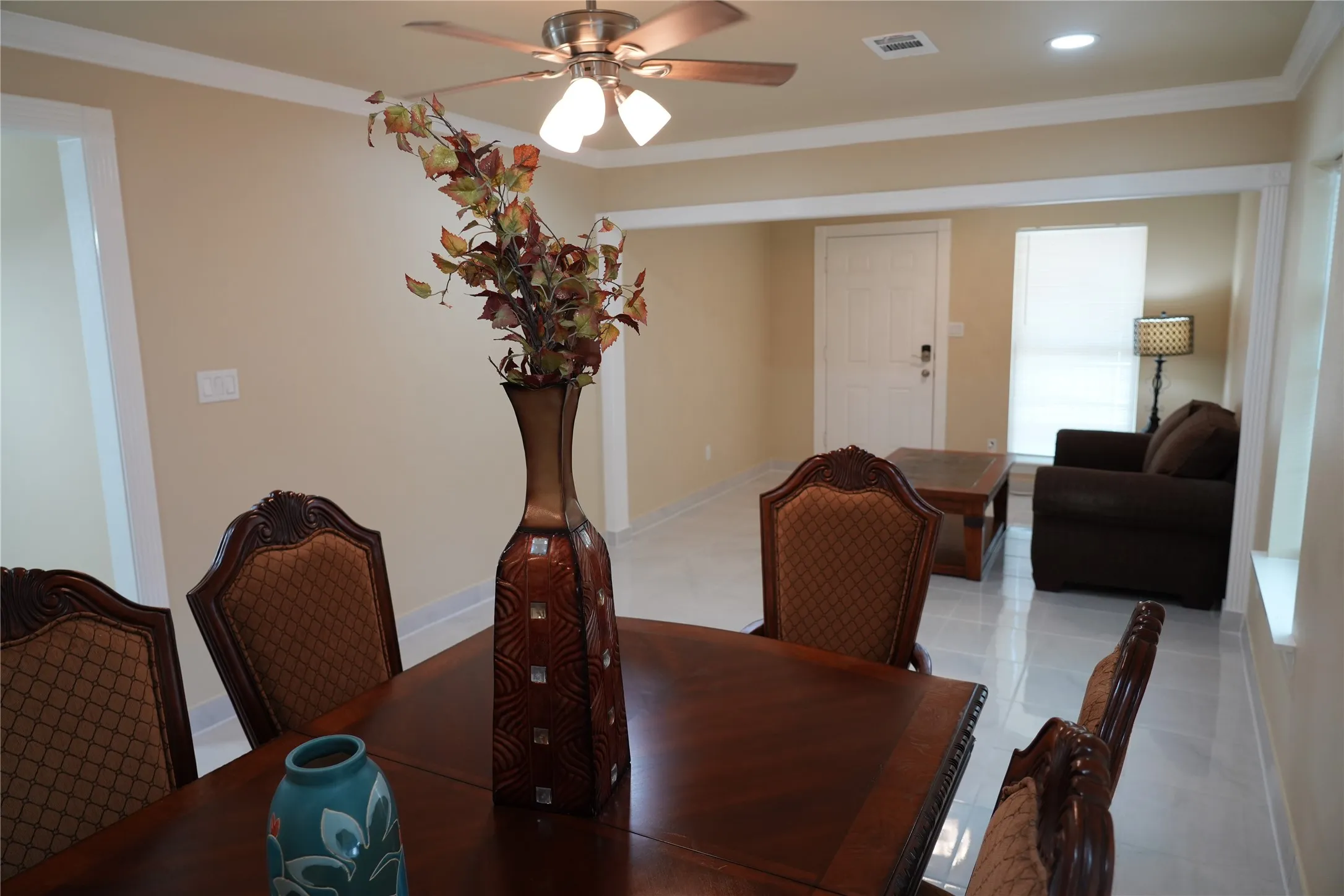 Recessed lighting, ceiling fan, crown molding, light-toned wall paint, and white tile flooring