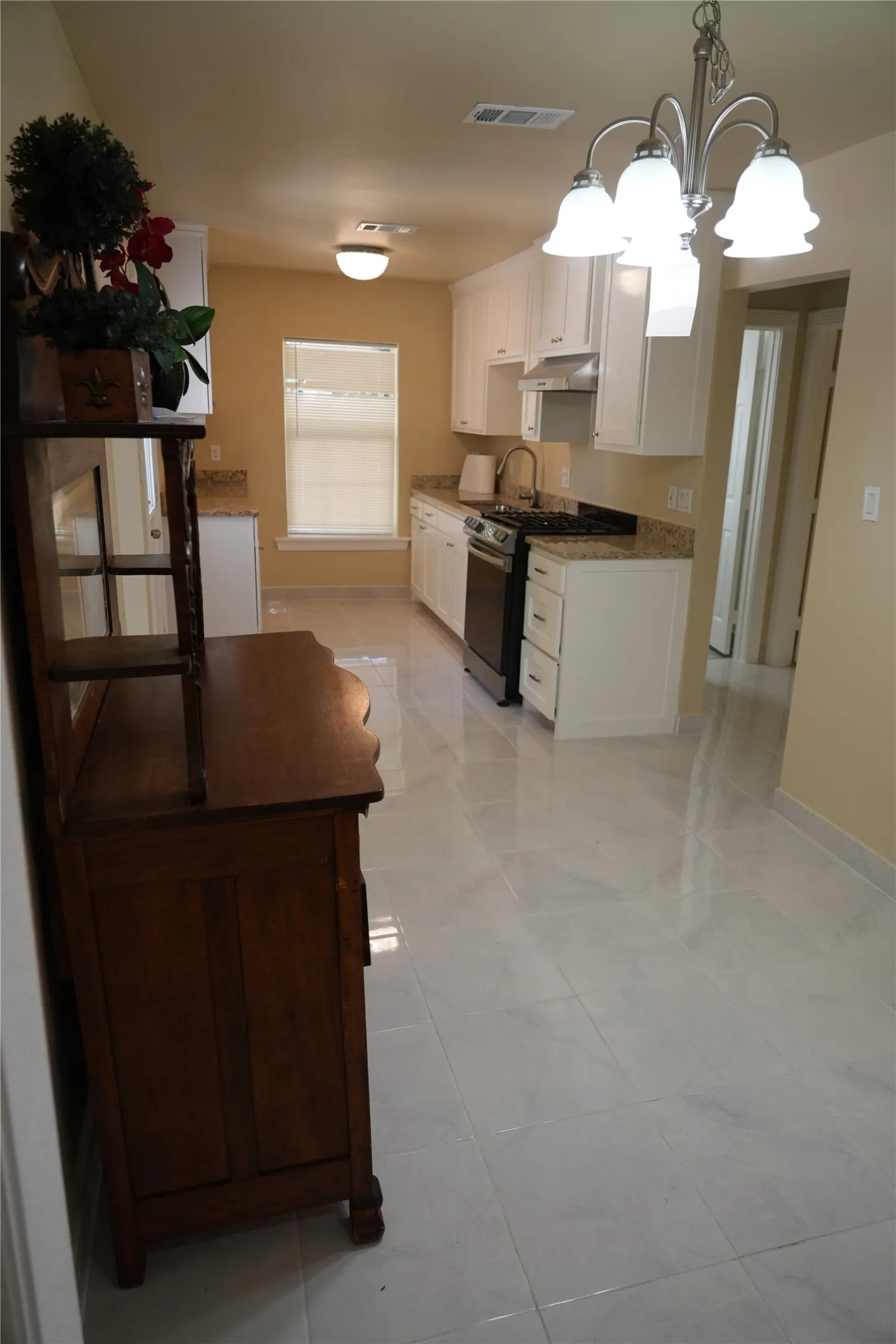 Kitchen featuring white cabinetry, light-colored countertops, stainless steel appliances, and tile flooring