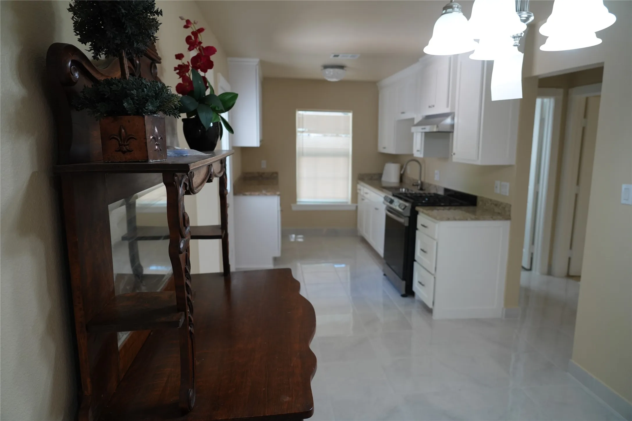 Kitchen featuring white cabinetry, light-toned countertops, tile flooring, and stainless steel appliances