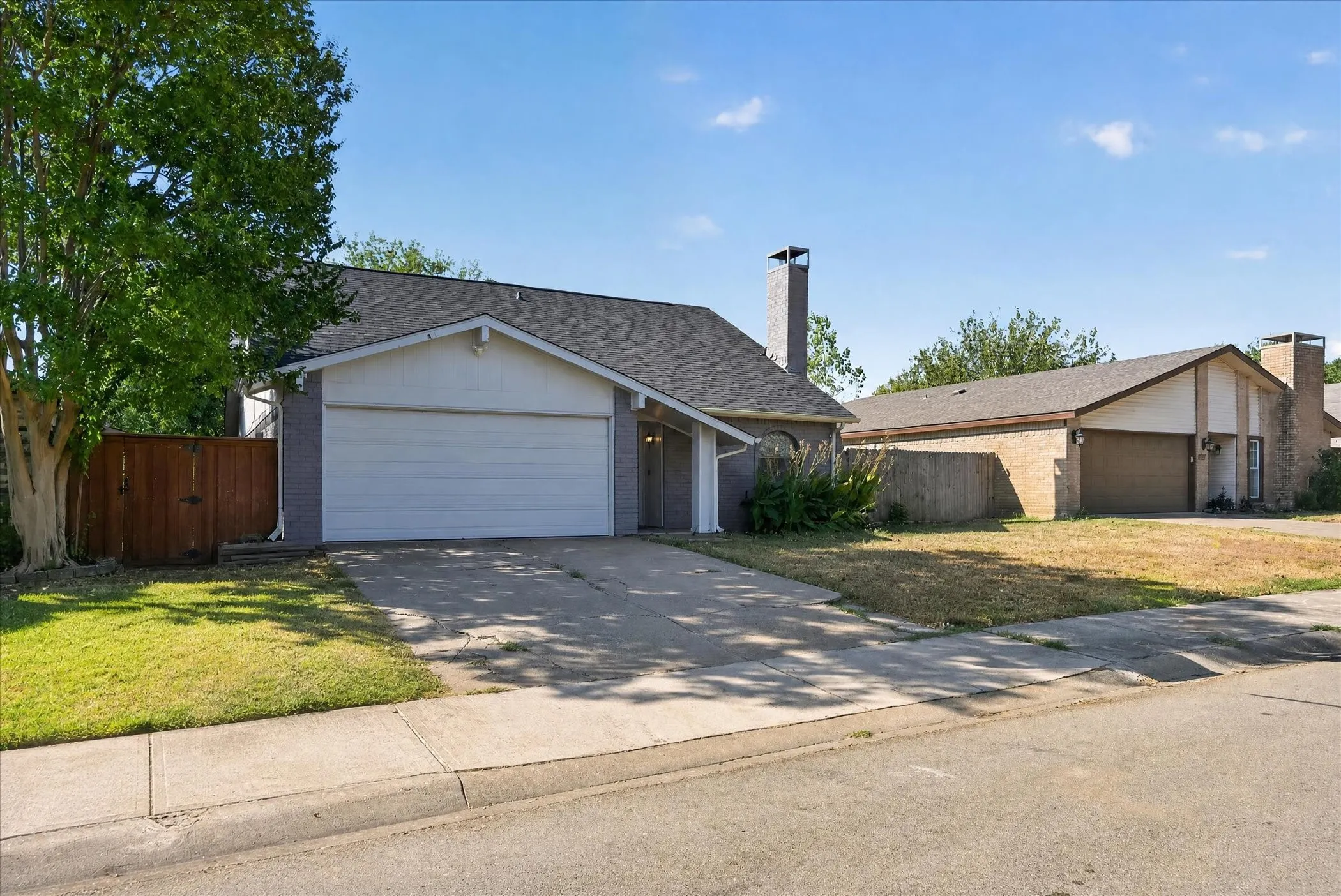 Attached two-car garage, concrete driveway, and a wood privacy fence