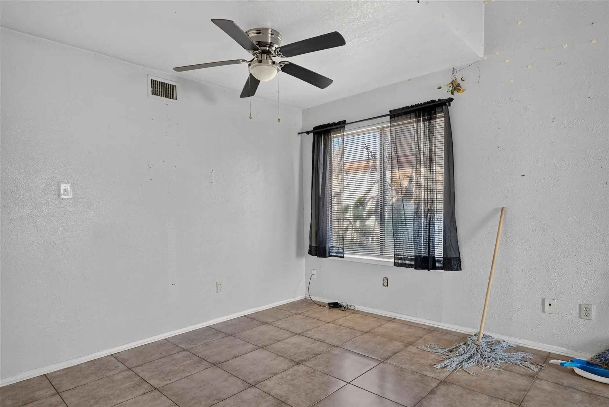 Recessed window with a ceiling fan light fixture and tiled flooring
