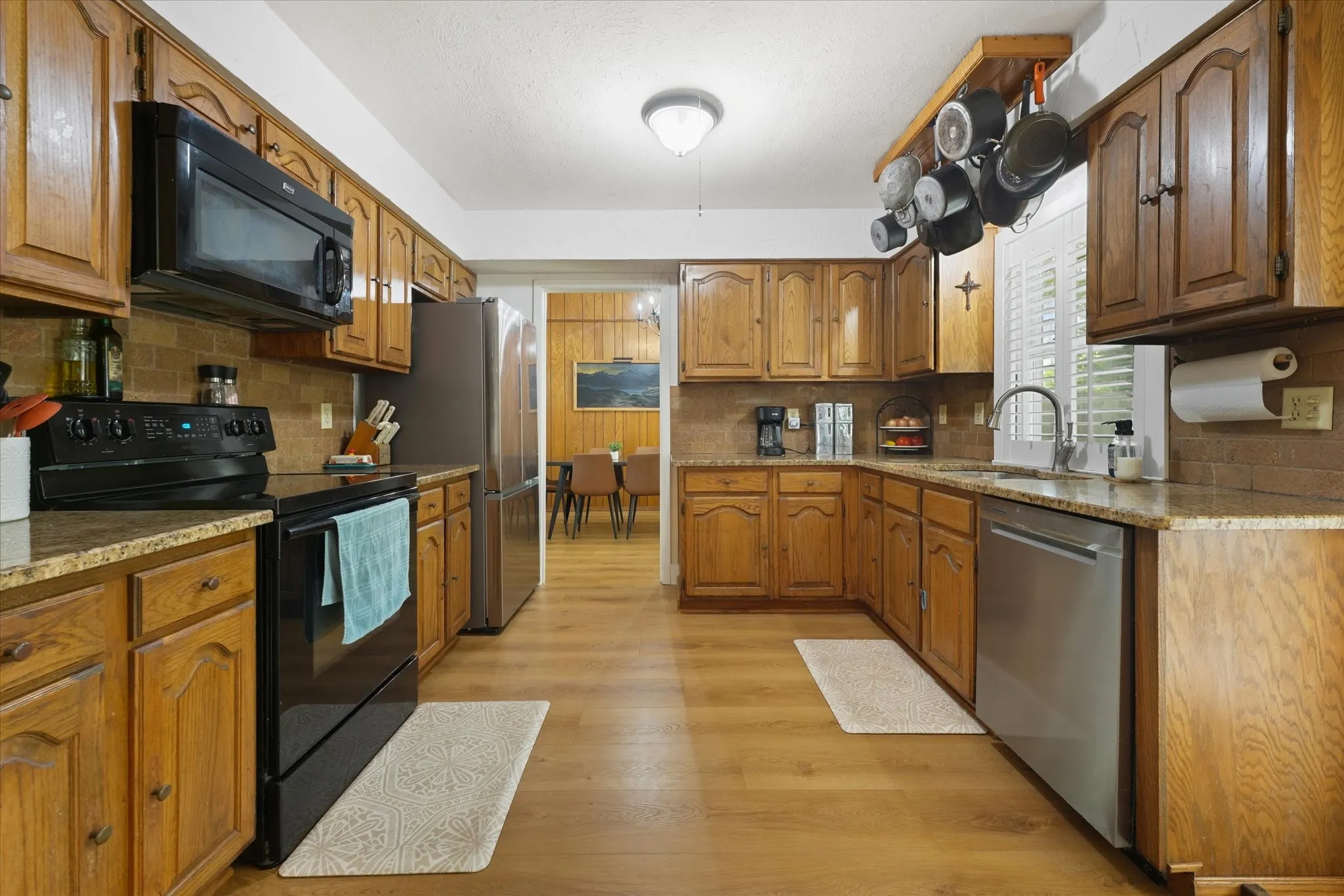 Kitchen features granite counters, ss appliances and black appliances with lots of cabinet space.