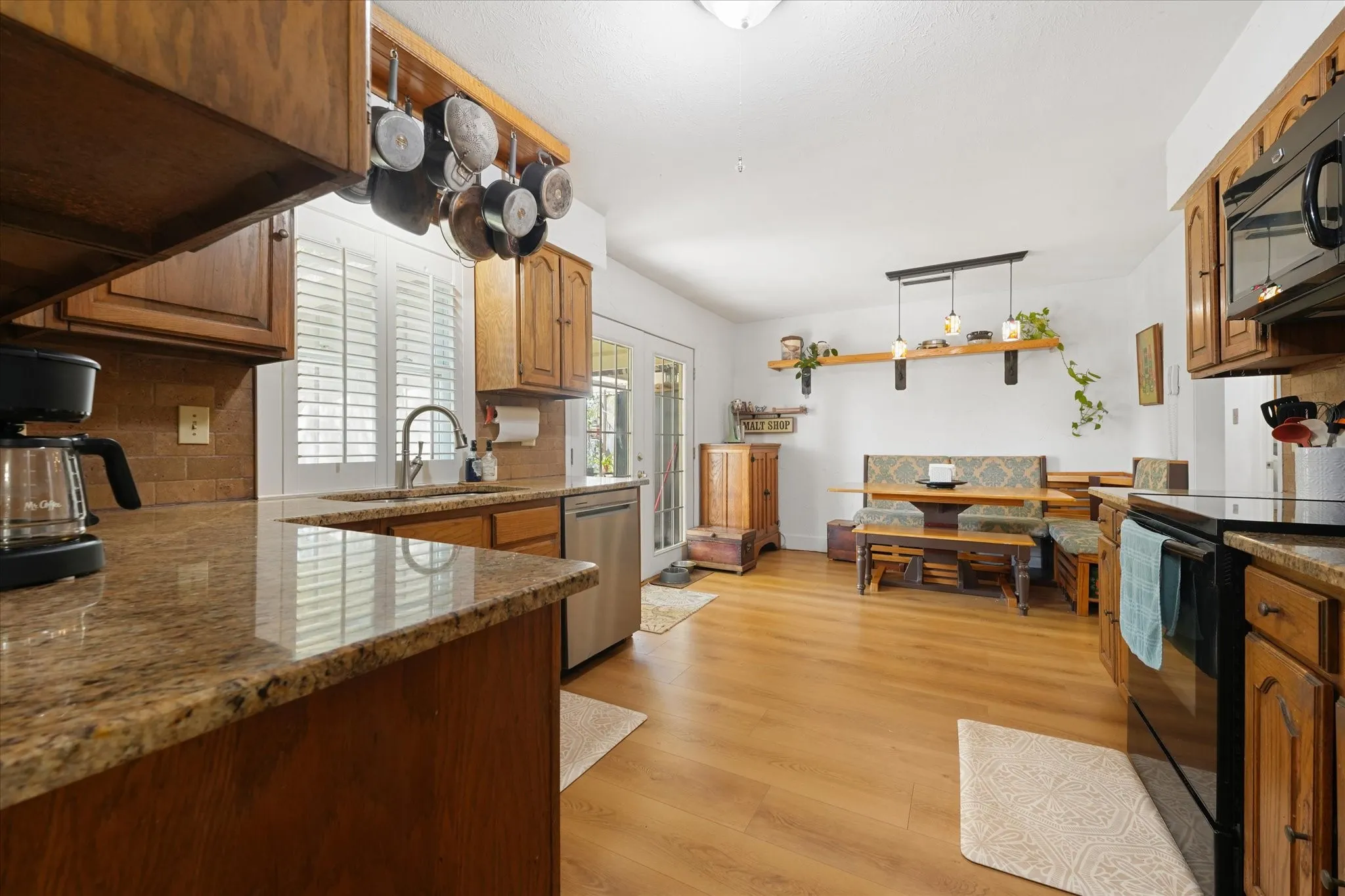 Kitchen features granite counters, ss appliances and black appliances with lots of cabinet space.