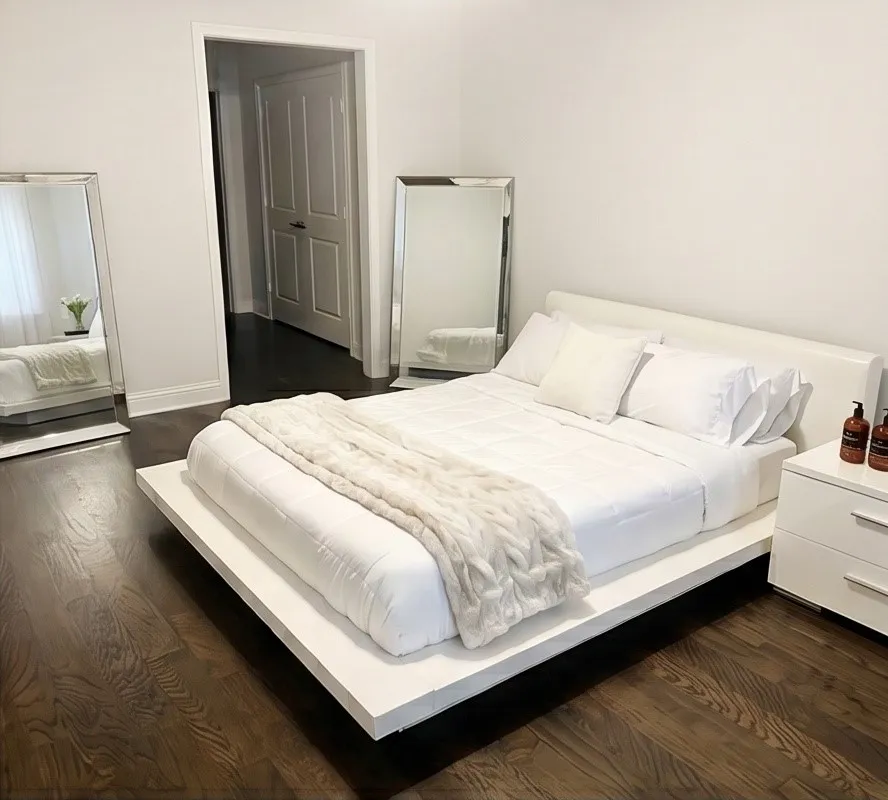 Dark wood-finish flooring, white walls, and a recessed doorway