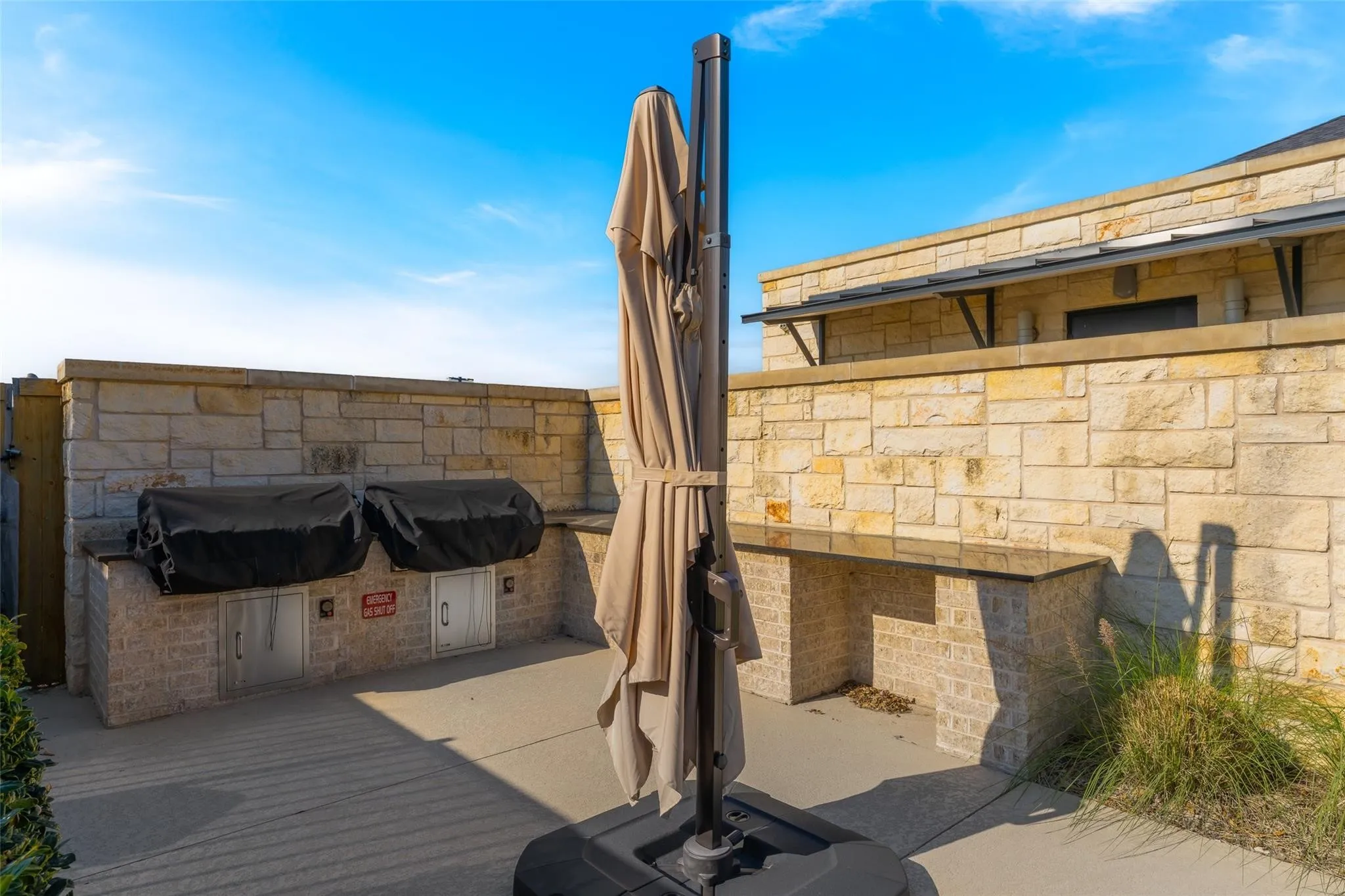 Outdoor kitchen with integrated grill stations, stone-clad construction, and built-in counter space