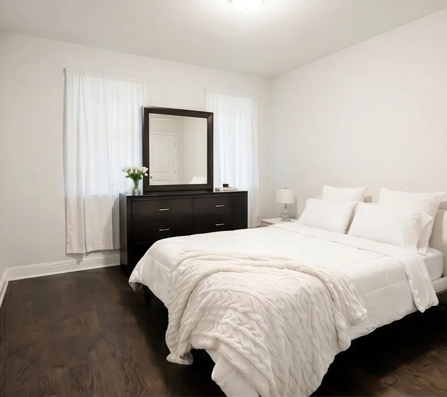 Wood-finish flooring with white trim, bright white walls, and a recessed ceiling light