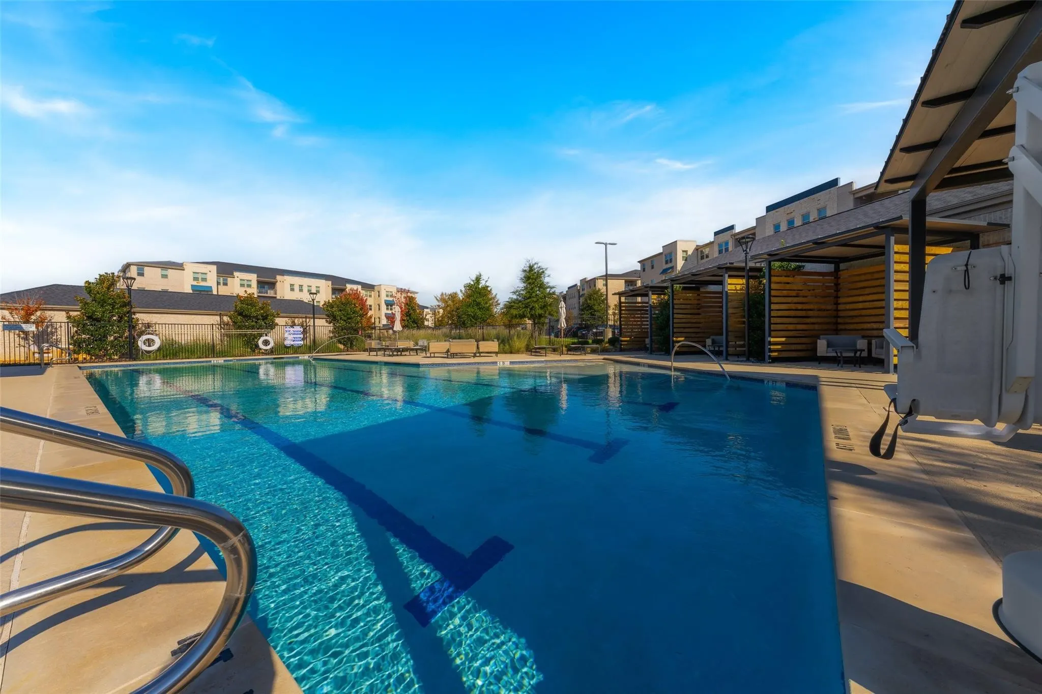 Swimming pool with lap lanes and integrated entry stairs, surrounded by a concrete deck