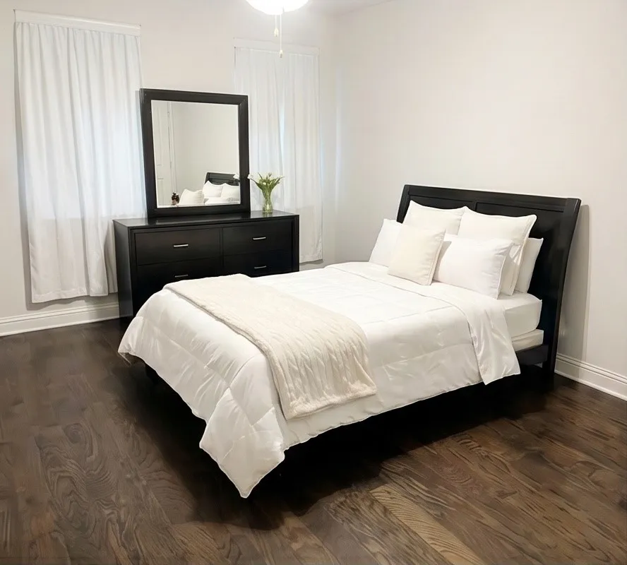 Rich wood-finish flooring, bright white walls, and elegant window treatments create a serene atmosphere