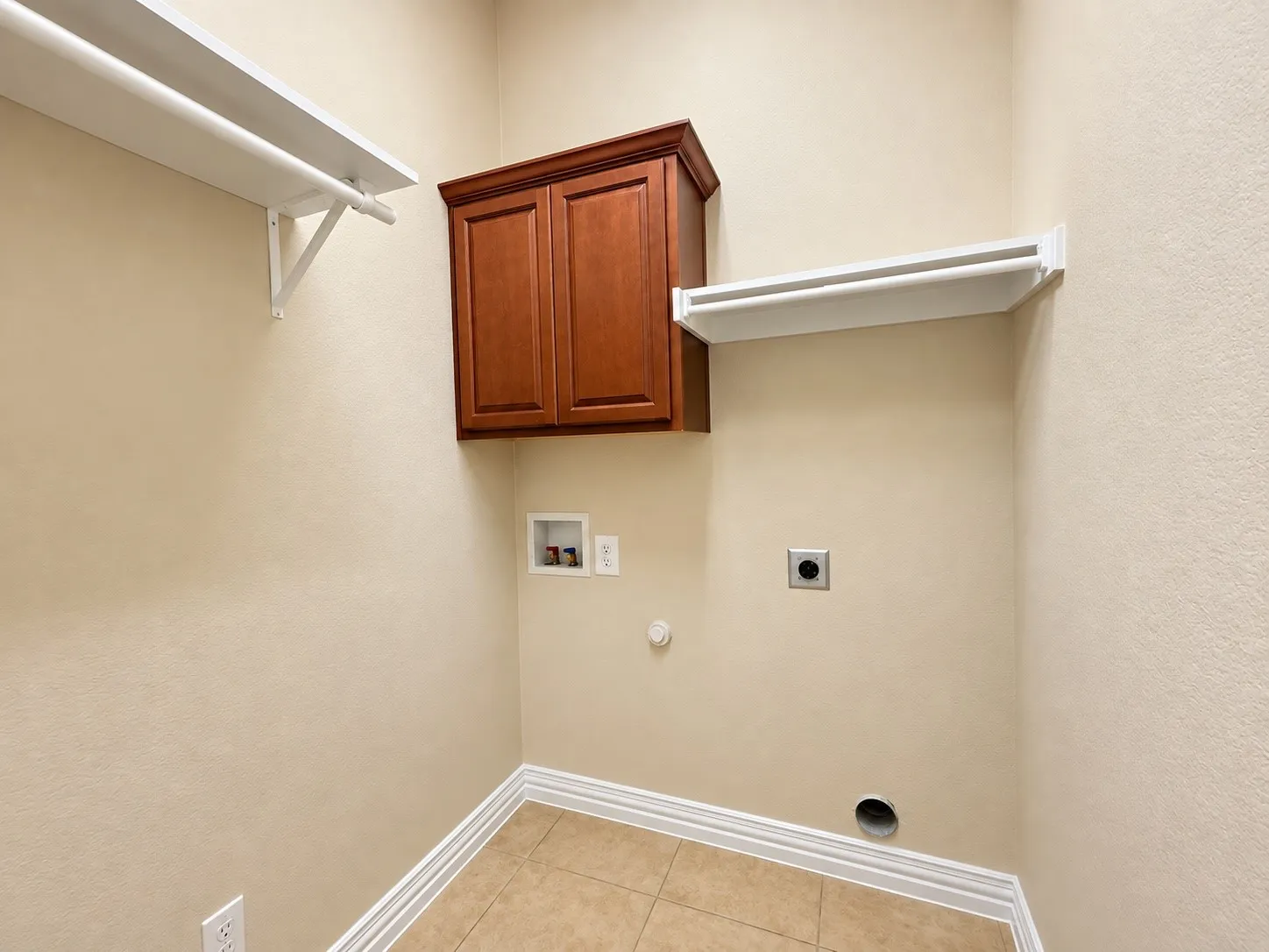 Built-in cabinetry, wall shelving, and tile flooring