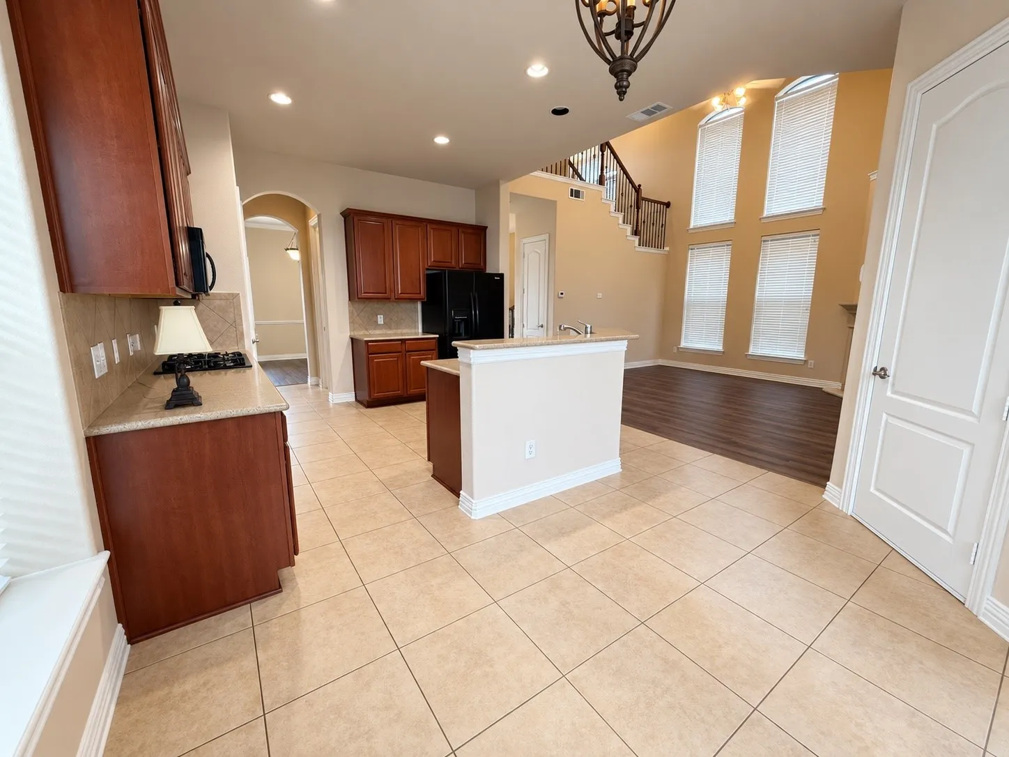 Kitchen featuring wood cabinetry, stone countertops, and tile flooring