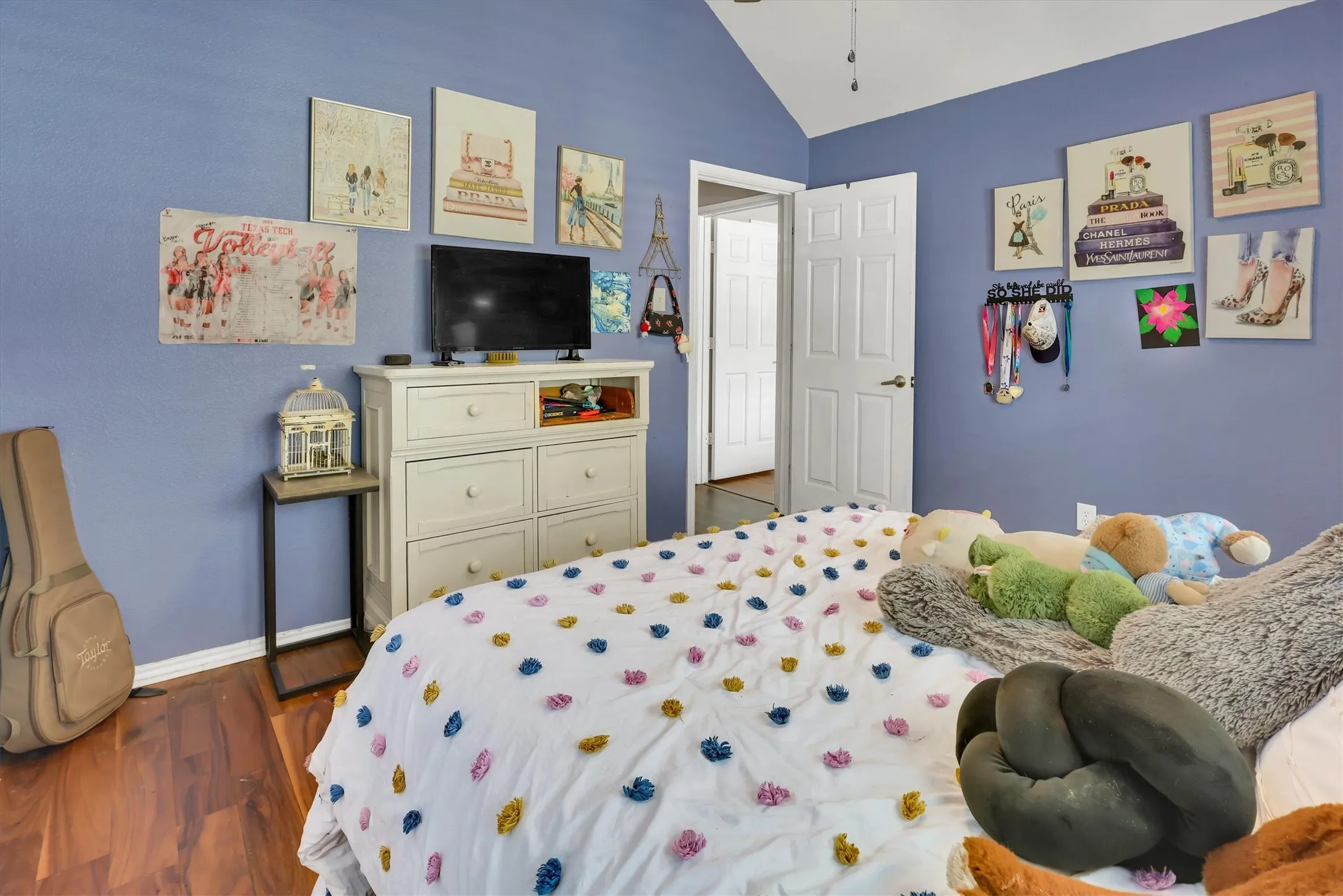 Vaulted ceiling with a ceiling fan, wood-finish flooring, and a white six-drawer dresser with open shelving