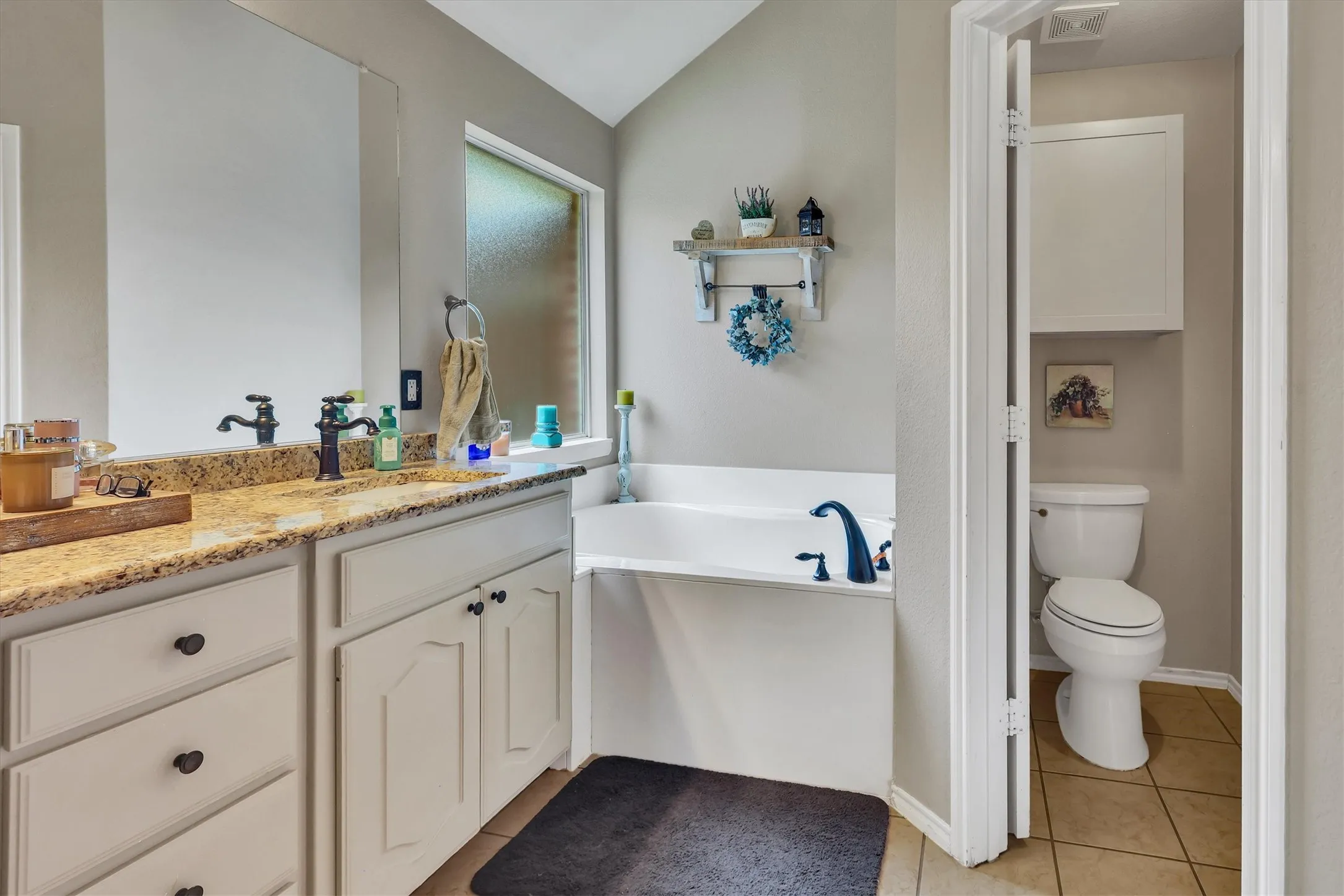 Dual vanity with stone-finish countertop, undermount sinks, and dark-finish fixtures