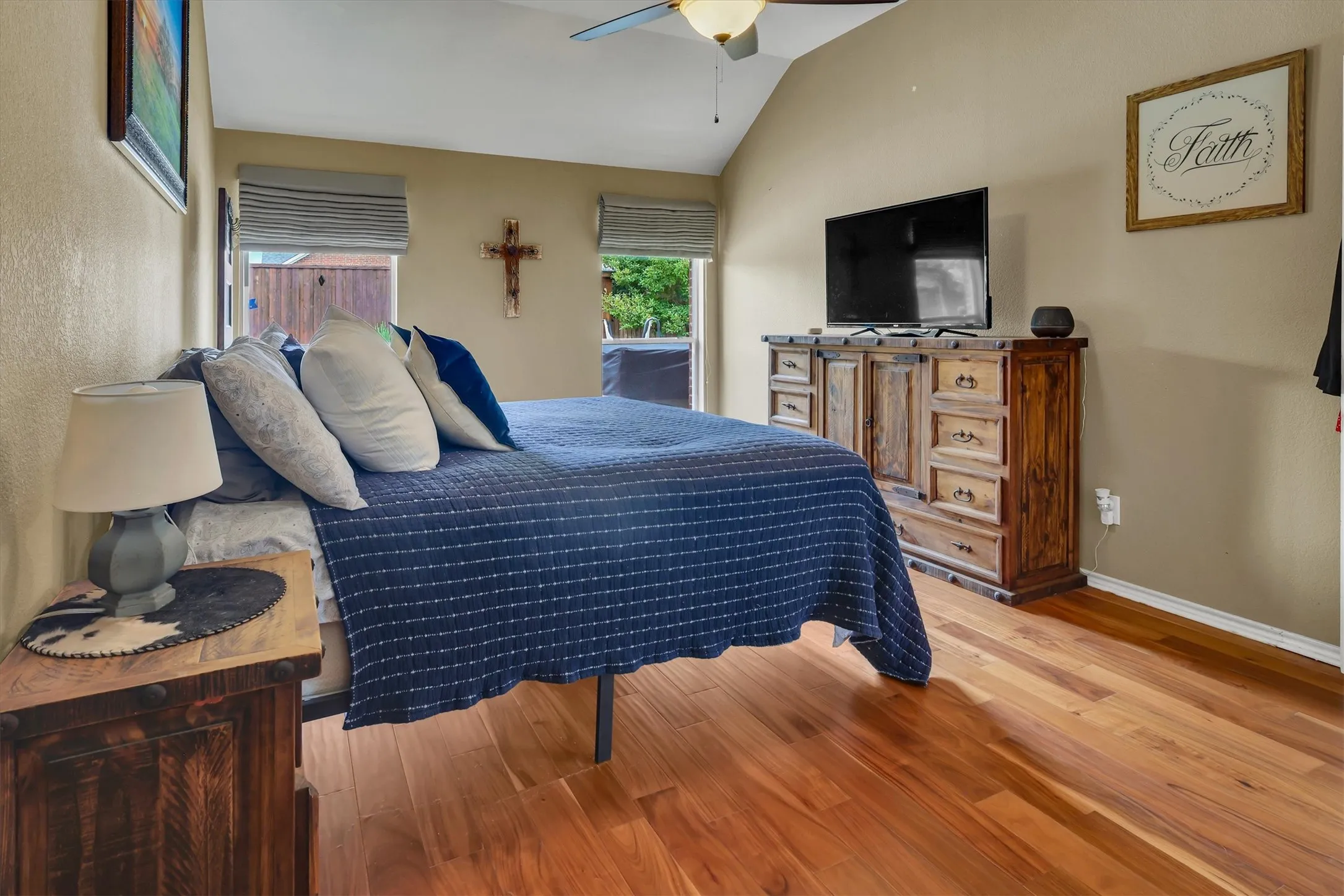 Sloped ceiling with a ceiling fan, recessed windows with blinds, and wood-finish flooring