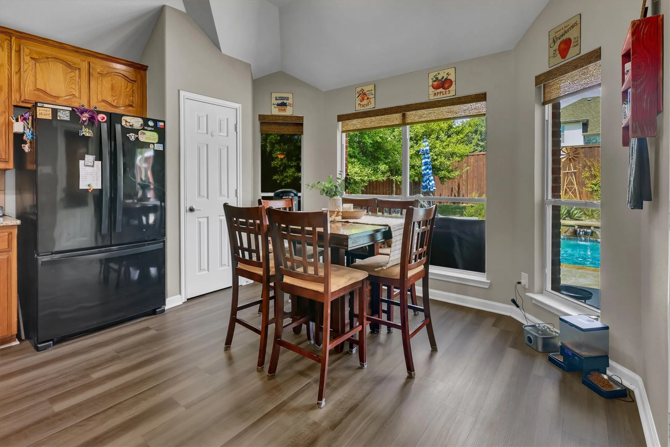 Kitchen with wood-finish flooring, vaulted ceiling, and multiple windows