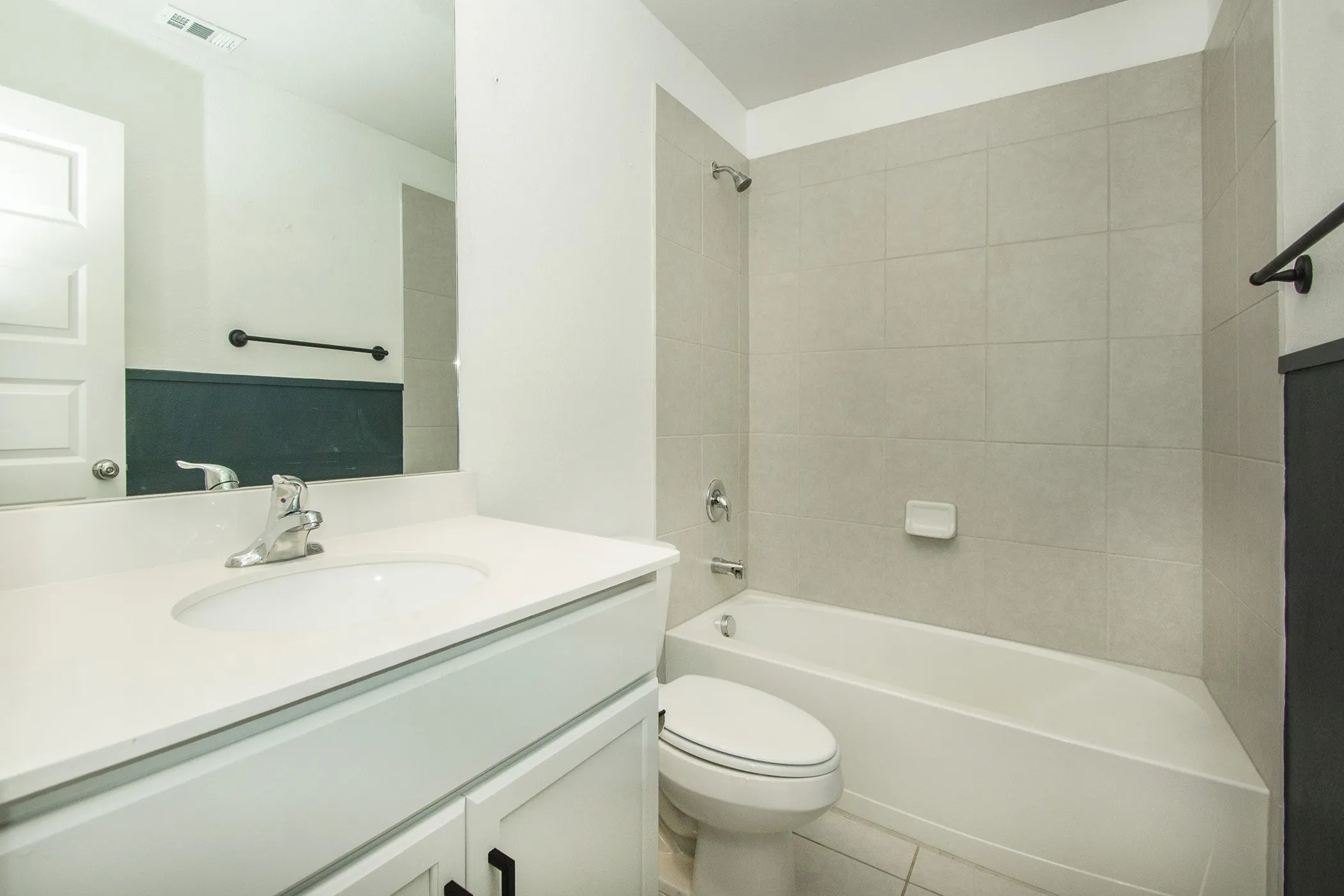 Bathroom featuring vanity, shower / tub combination, and tile patterned floors