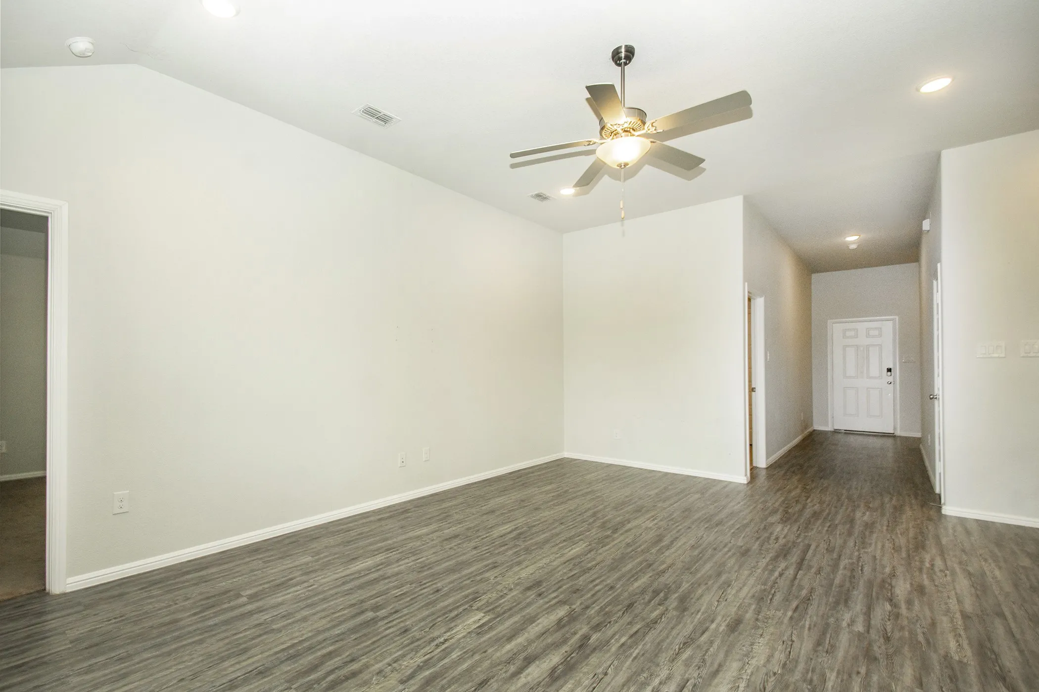 Empty room featuring ceiling fan, recessed lighting, and dark wood-type flooring