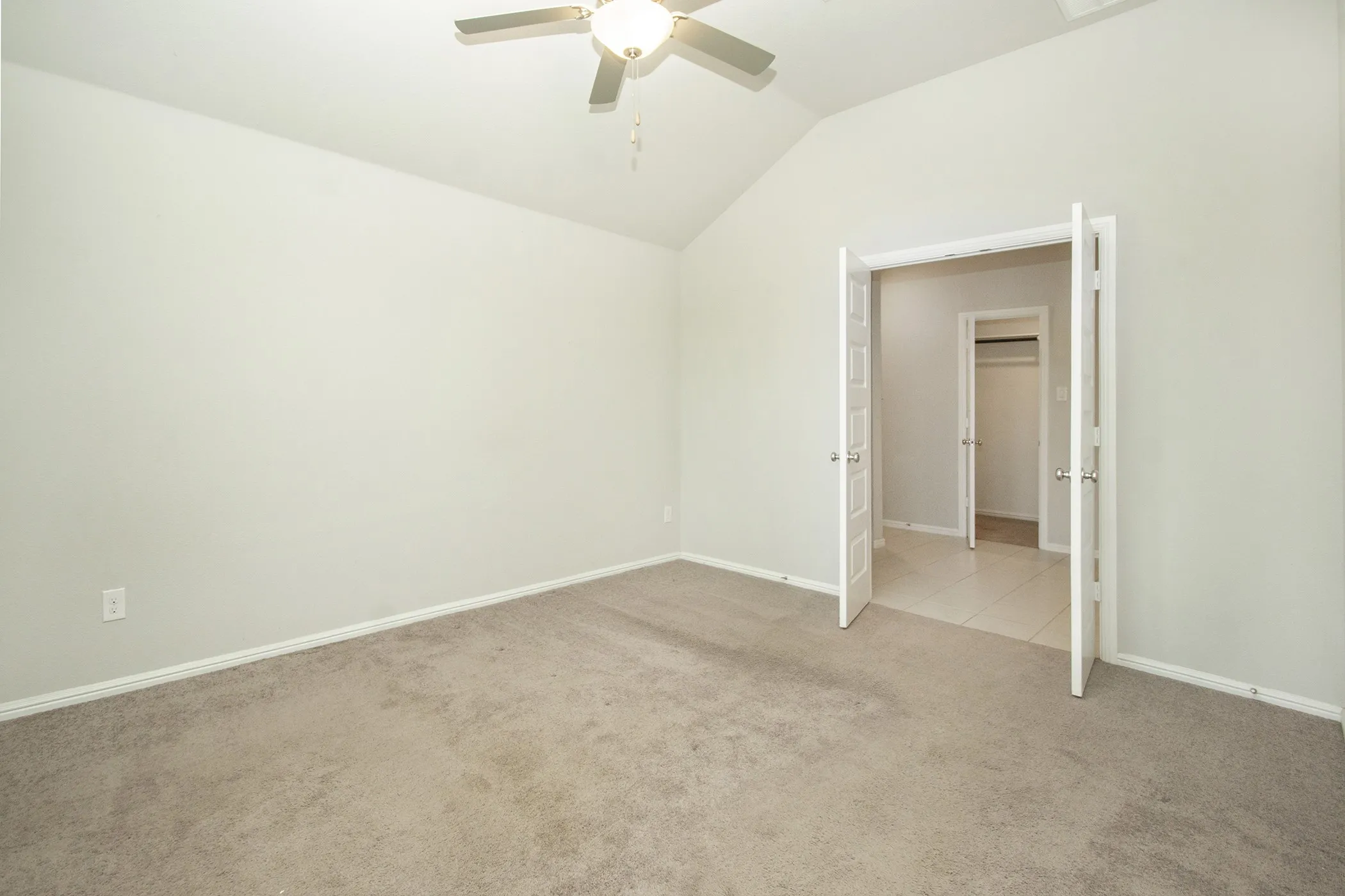 Spare room with light carpet, lofted ceiling, and ceiling fan