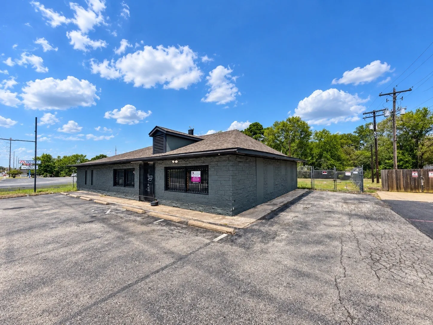 Commercial building with a dark-painted exterior, multiple windows, and a sloped roofline