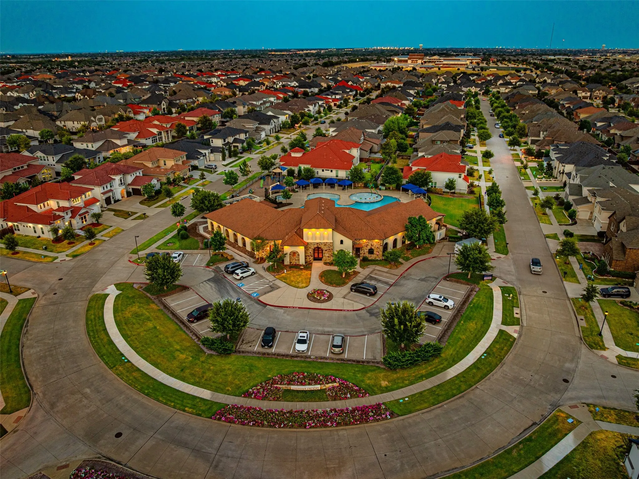 Community with a central amenity building, surrounding residences, and manicured green spaces