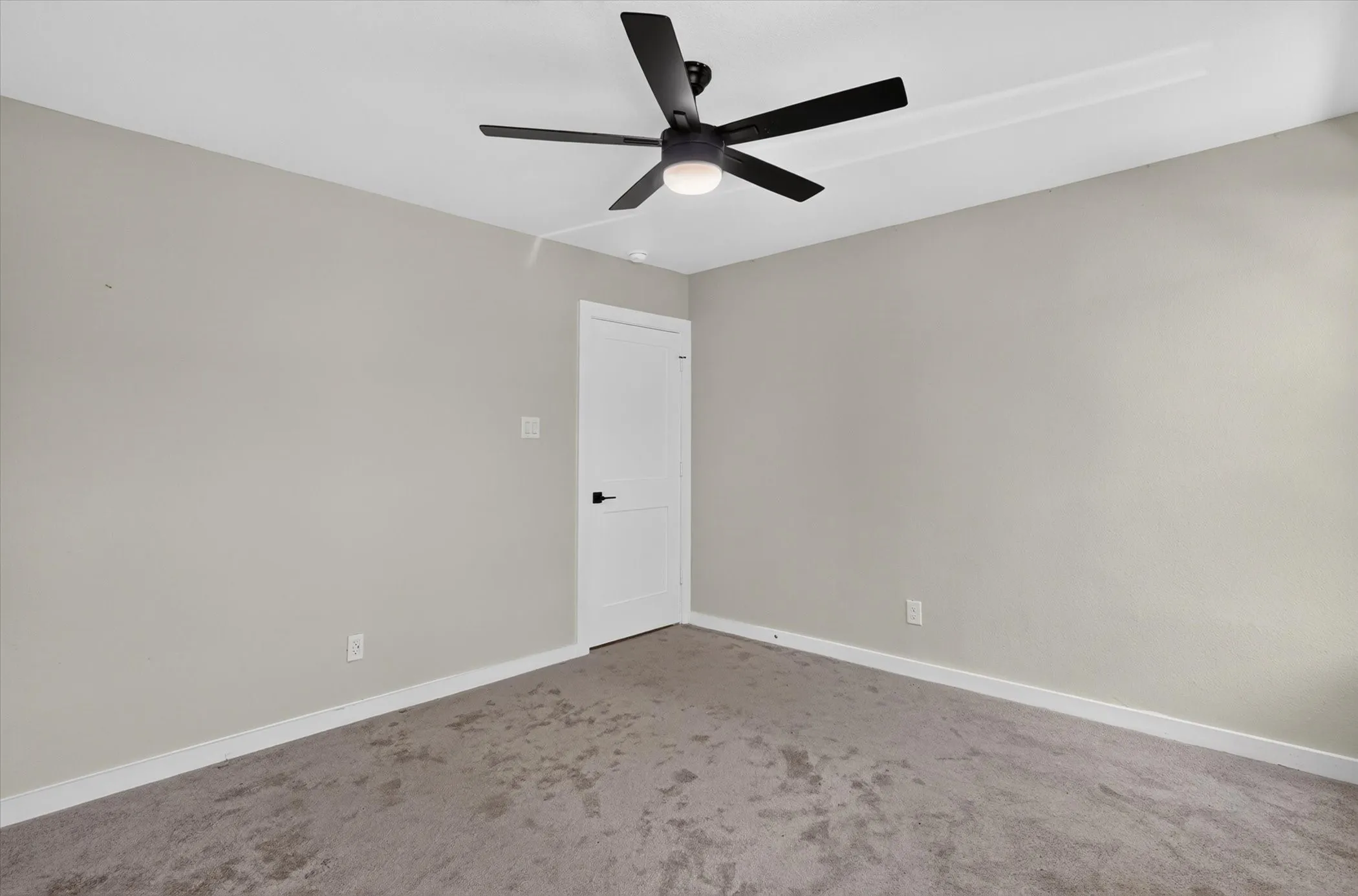 Neutral tone wall finish with a ceiling-mounted fan and integrated lighting