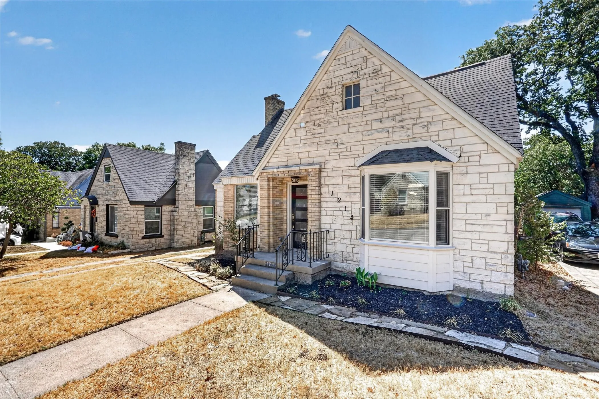 Stone exterior with a prominent bay window, dark-toned roofing, and a stone chimney